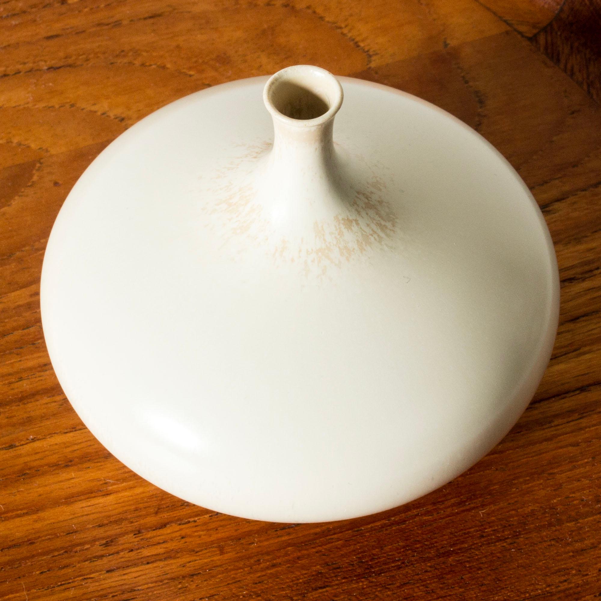 Unico vaso in miniatura in gres di Stig Lindberg, dalla forma liscia e a goccia con un collo sottile. Smaltato di bianco guscio d'uovo con un discreto motivo grafico intorno al collo.