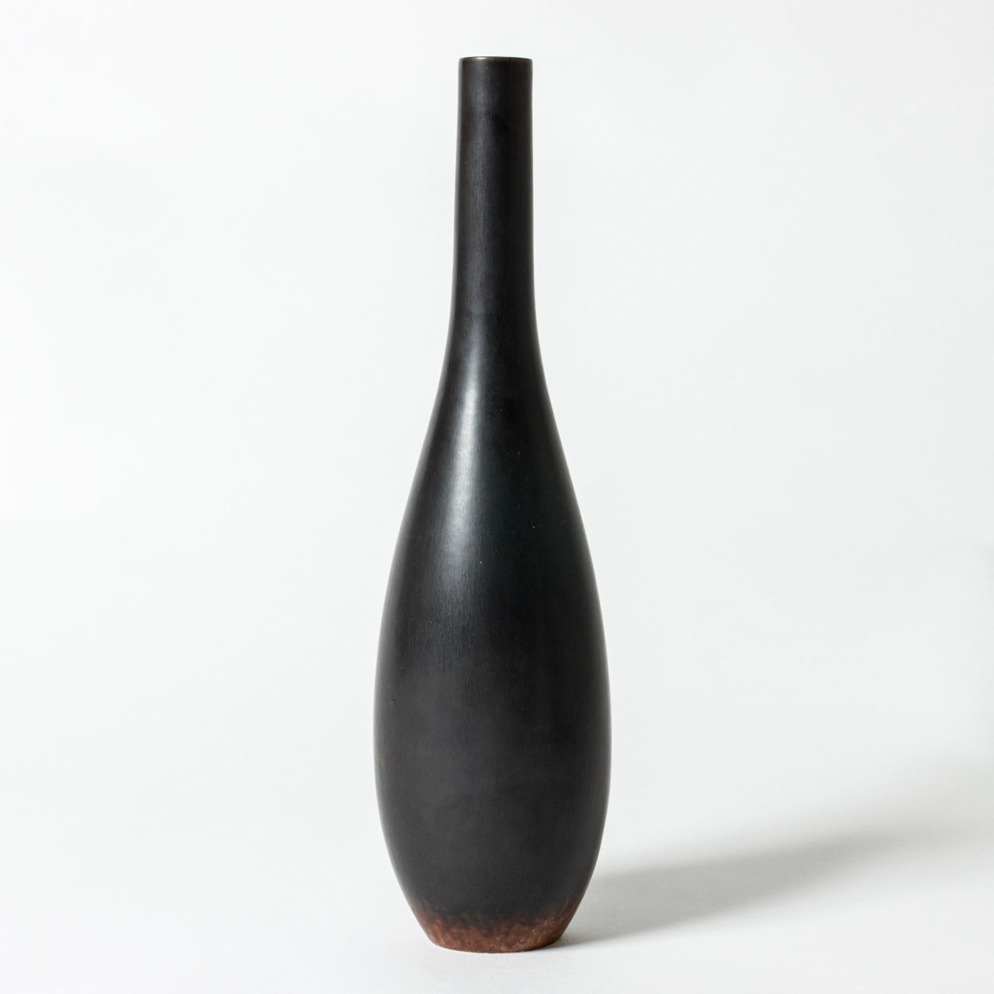Striking stoneware vase by Carl-Harry Stålhane in a narrow, drop-shaped form. Jet black glaze with rusty color around the base.

Carl-Harry Stålhane was one of the stars among Swedish ceramic artists during the 1950s, 1960s and 1970s, whose