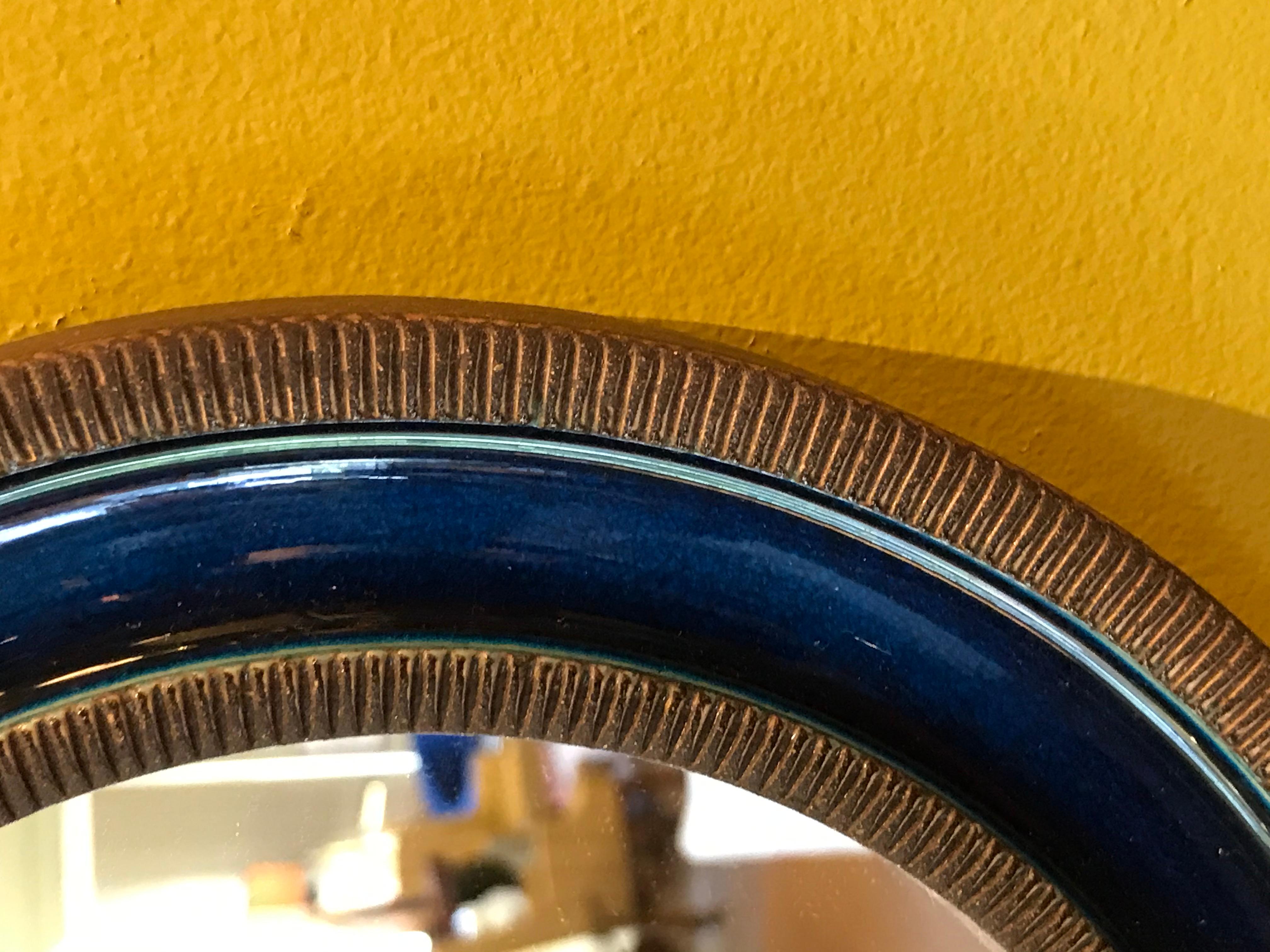 Stoneware round mirror by Erik Reiff for Knabstrup, Denmark from the late 1960s. This mirror has a stoneware textured feel on the edges and a soft smooth dark blue crystalline glaze on the inside. Very good condition with just one firing flaw on the