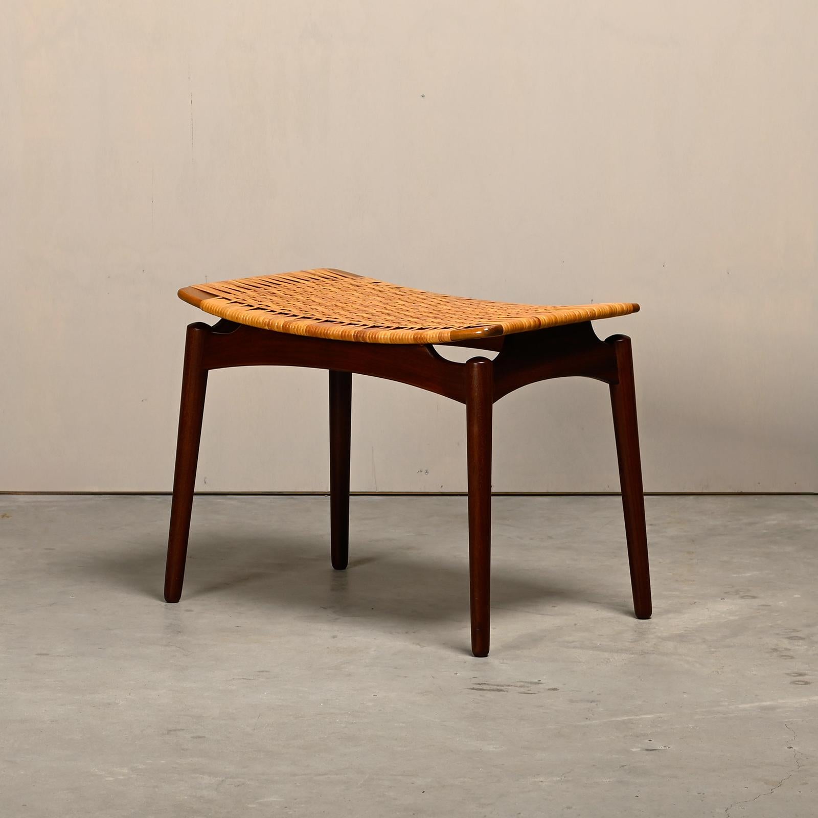 Beautifully designed Scandinavian modern stool by Sigfred Omann for Ølholm Møbelfabrik, Denmark in the 1950s. Solid teak frame with handwoven cane seat. The round tapered legs and the recessed corners gives the seat a floating appearance. Very good