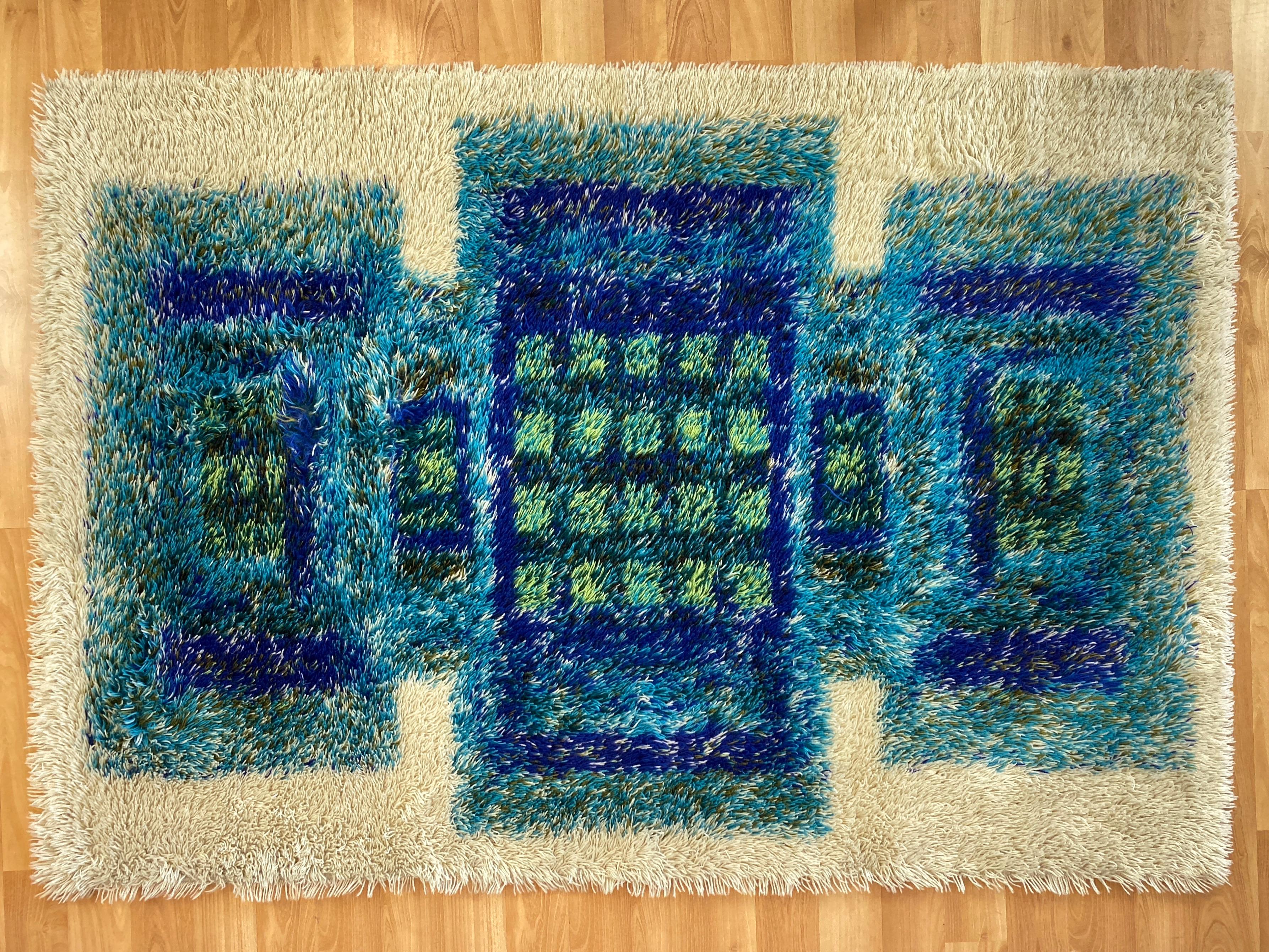 A 1960s Scandinavian Modern-style “Rya Sapphire” pattern 100% wool rug made in Austria exclusively for the “Connoisseur Rug Collection” by Sears.

Features a rich and vibrant jewel and semi-precious stone-colored design comprised of squares and