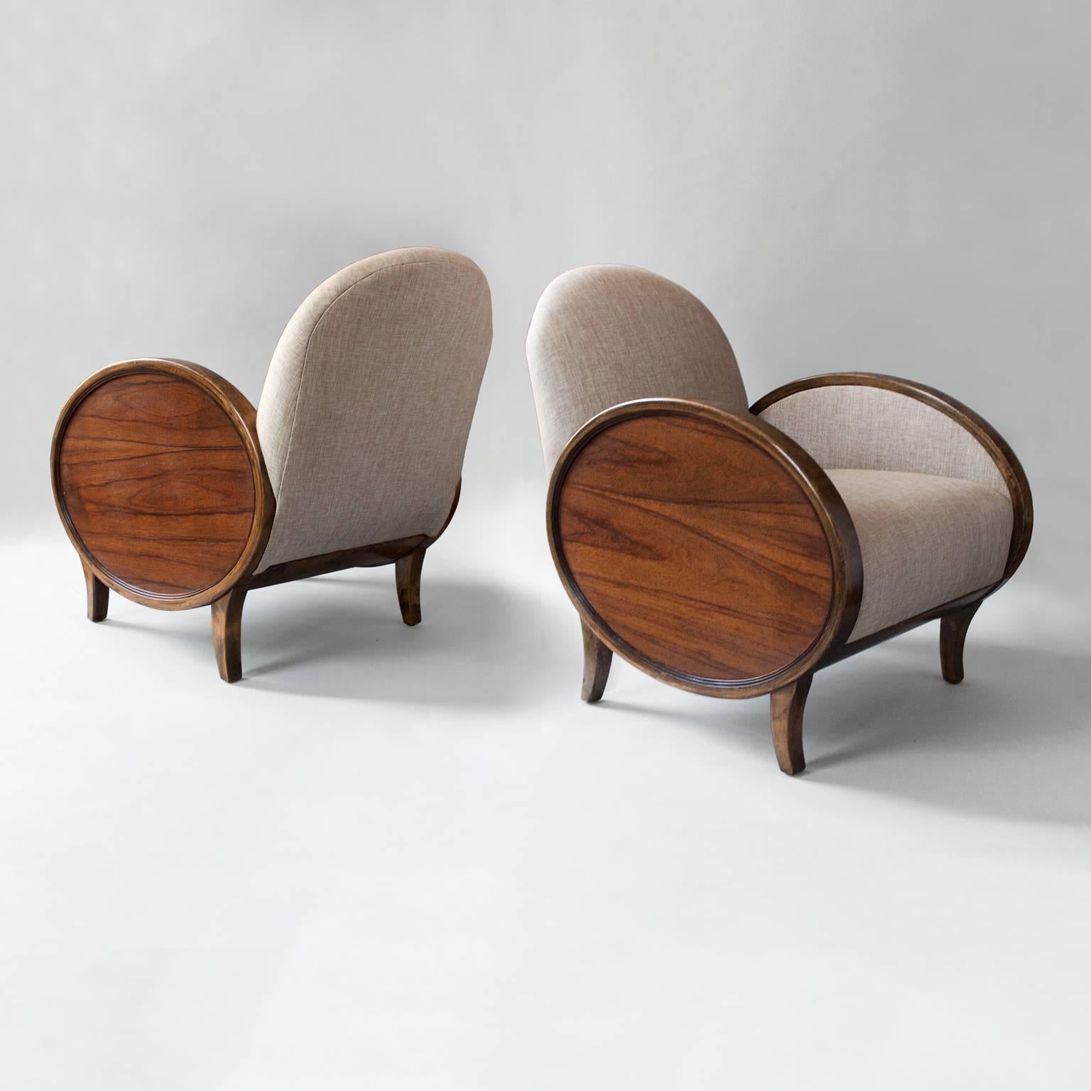 Pair of Scandinavian Modern Swedish Art Deco bergères with solid stained birch frames and oval rosewood side panels. The dramatic oval side panels look as modern today as they must have in the 1930's. Newly restored and upholstered. Measures: Height