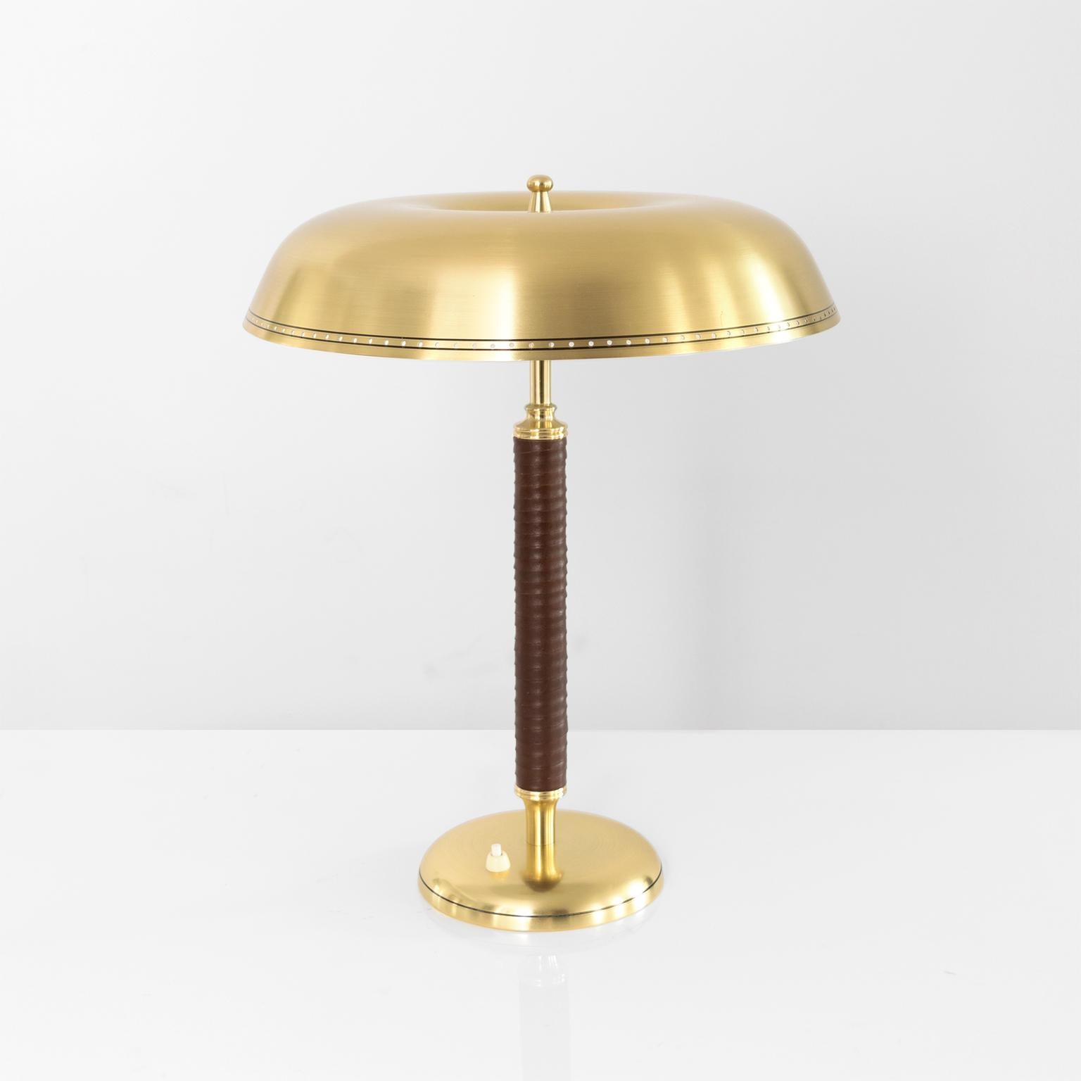 Scandinavian Modern Swedish Mid-Century Modern table lamp with polished brass shade and base with a leather wrapped stem. Newly restored and rewired with double standard sockets and switch on base. Measures: Height