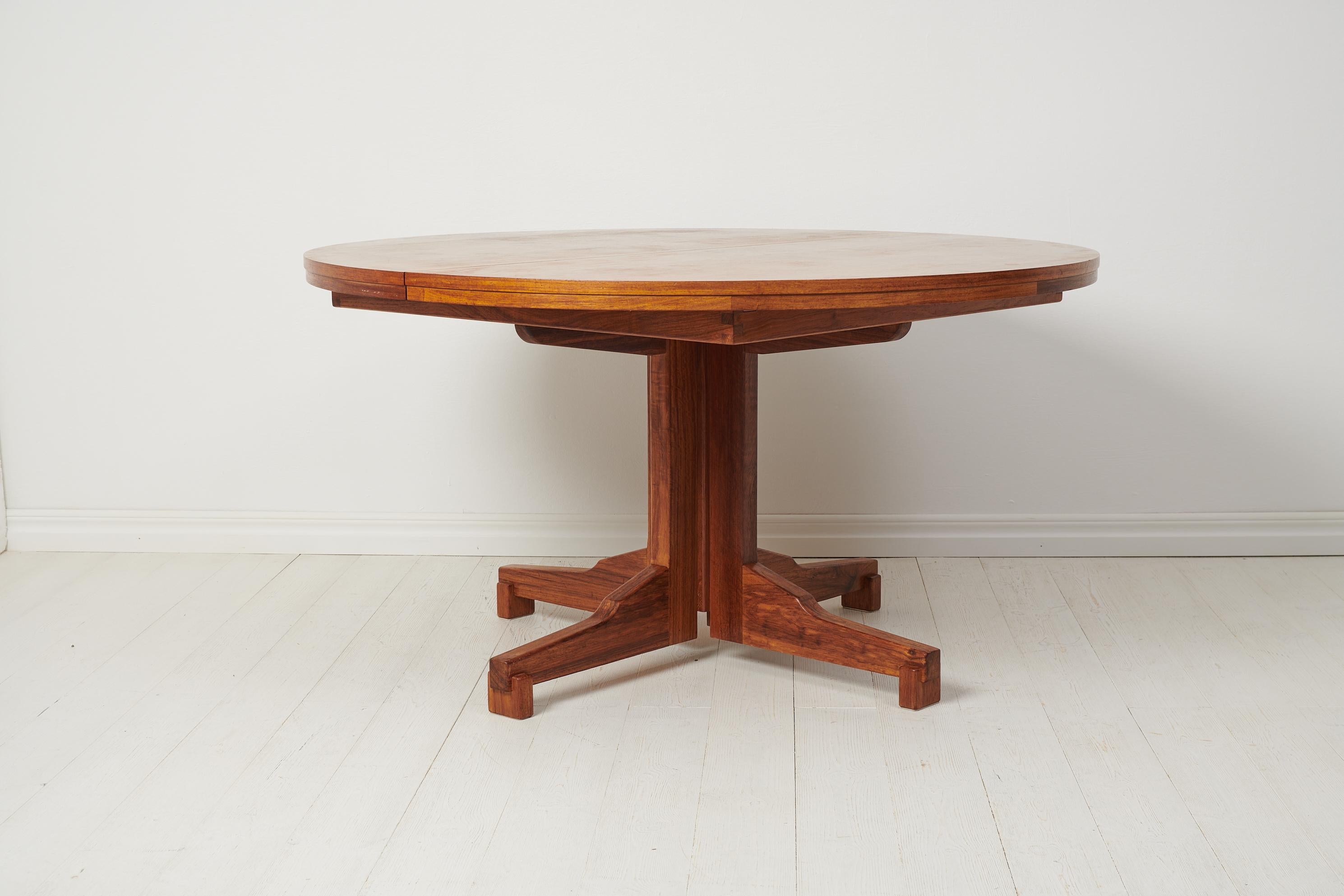 Scandinavian Modern dining table from Sweden made during the Mid-20th Century, around 1950 to 1960. The table is stylish and elegant with all the values of the Scandinavian Modern style. It is a good size with a round table top and two extra