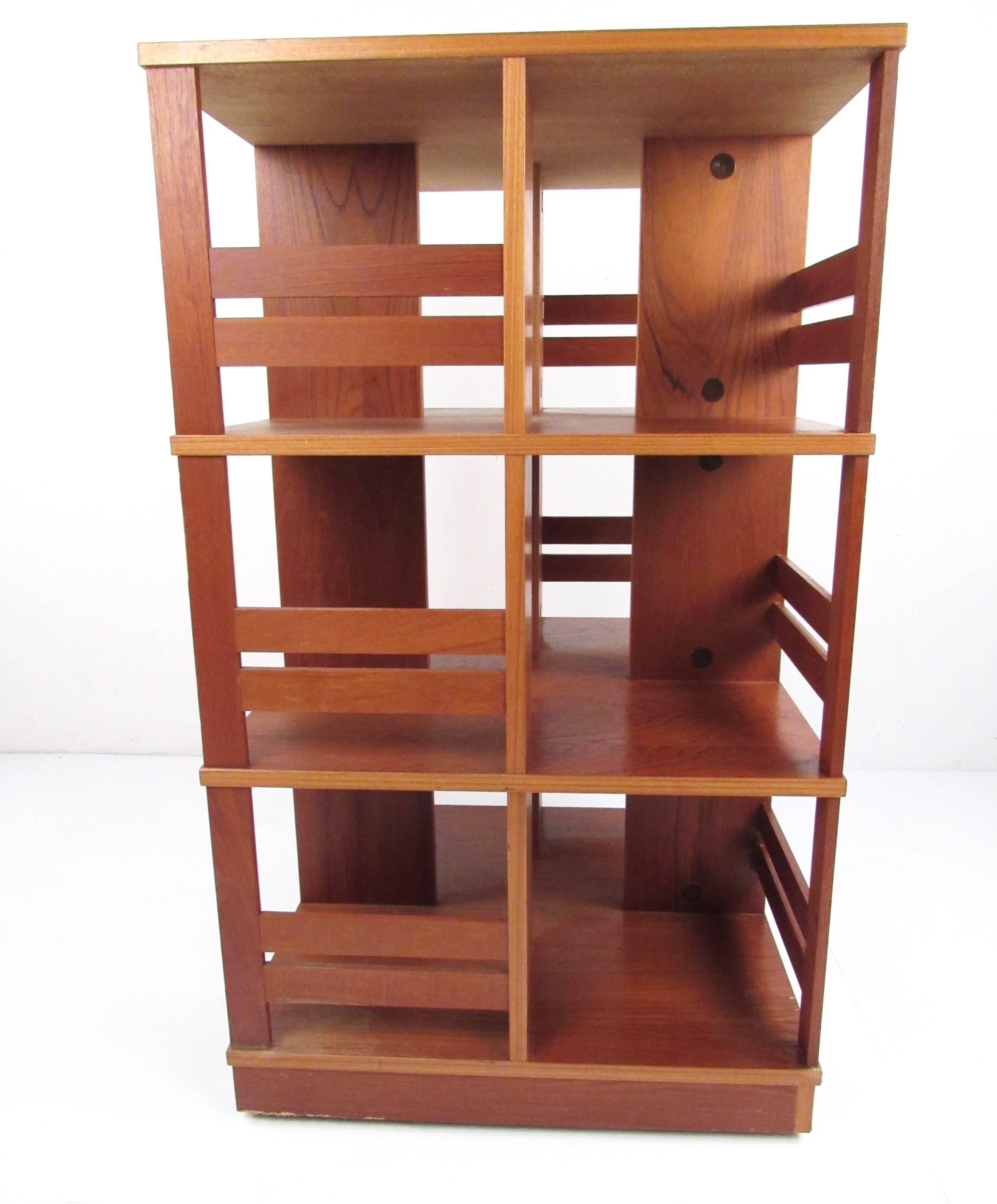 Cette bibliothèque moderne danoise en teck est dotée de plusieurs rangements latéraux et d'une base pivotante robuste. Idéal pour une bibliothèque ou une étagère de magasin. Veuillez confirmer la localisation de l'article (NY ou NJ).