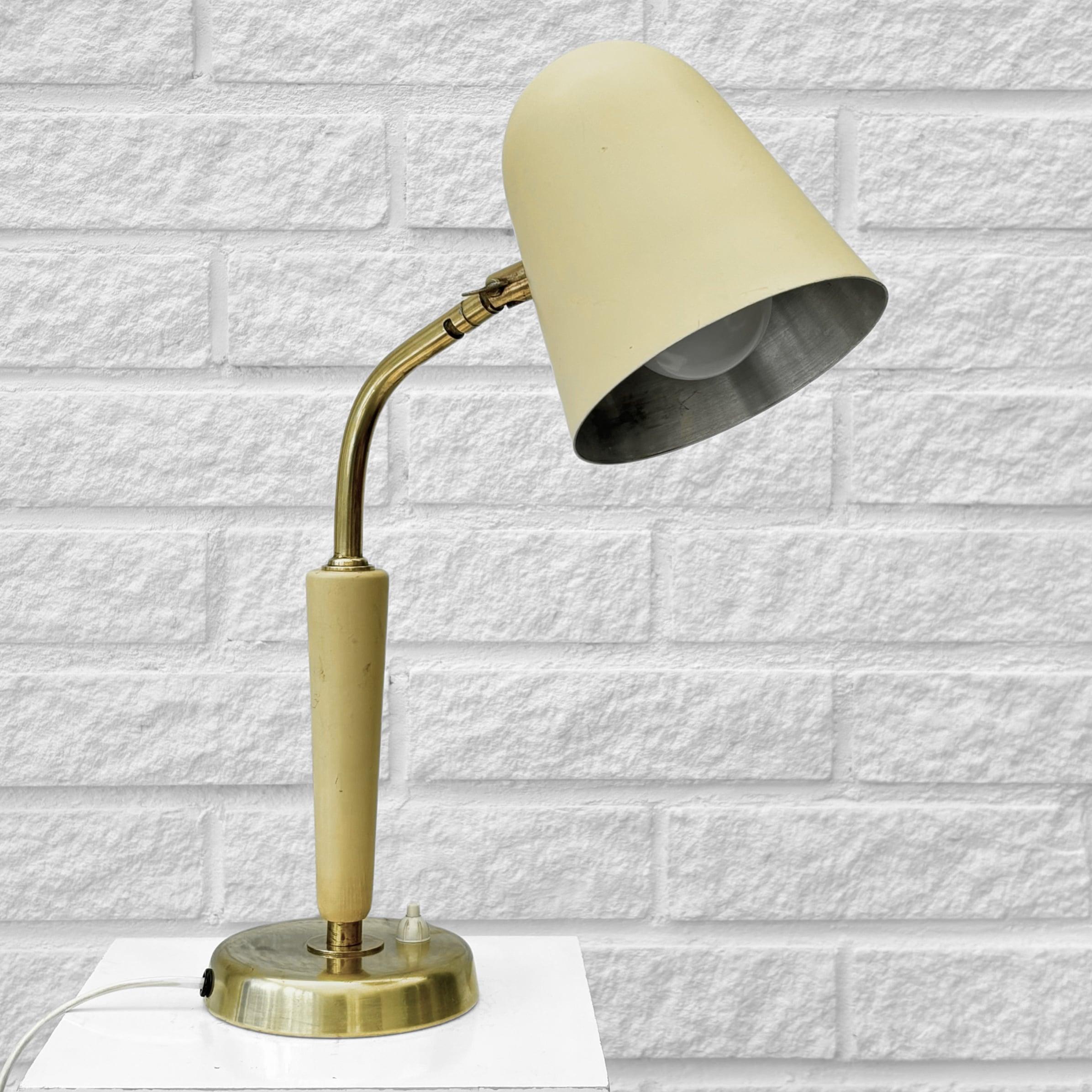 Lámpara de mesa modernista diseñada en la década de 1940 por Bertil Brisborg para los famosos grandes almacenes suecos Nordiska Kompaniet (NK). Fabricada en latón, acero y olmo, tiene una pantalla en forma de bala que puede ajustarse en varias