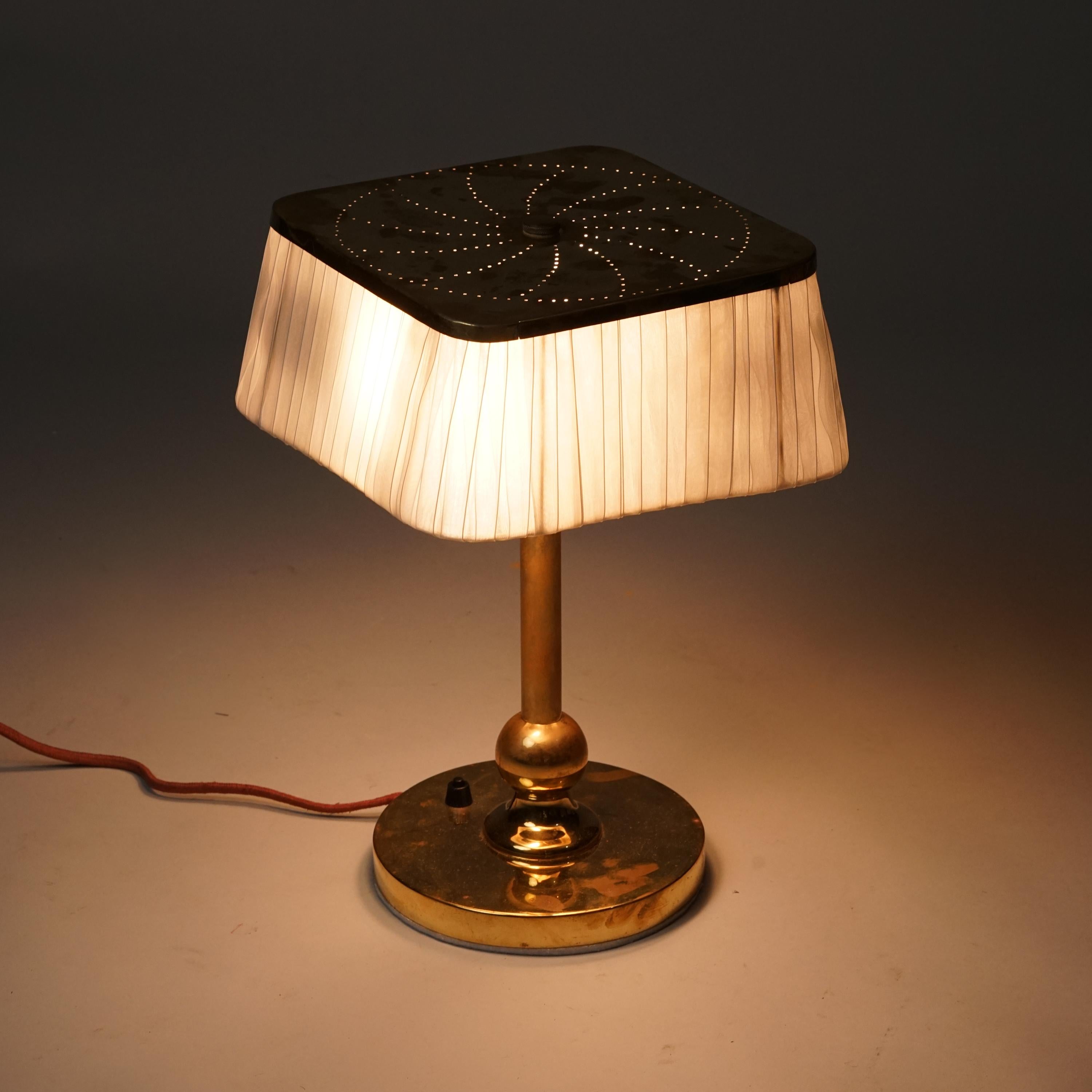 Lámpara de sobremesa moderna escandinava, fabricada en Finlandia, mediados del siglo XX. Marco de latón con un precioso diseño en la parte superior de la pantalla. Pantalla de tela. Buen estado vintage, pátina menor acorde con la edad y el uso. 
