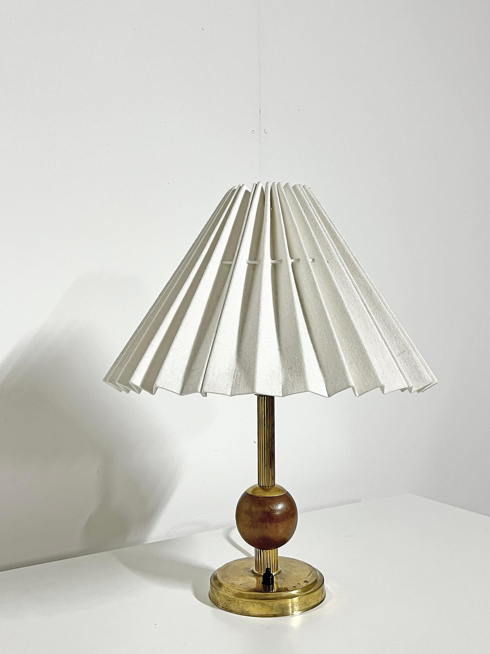 Scandinavian Modern table lamp in brass and wood ca 1960's. Anonymous. 
Wear and patina consistent with age and use. Some rust spots. Small crack on the base, see last picture. 
Please notice, the shade is not included!  
Original wiring. We