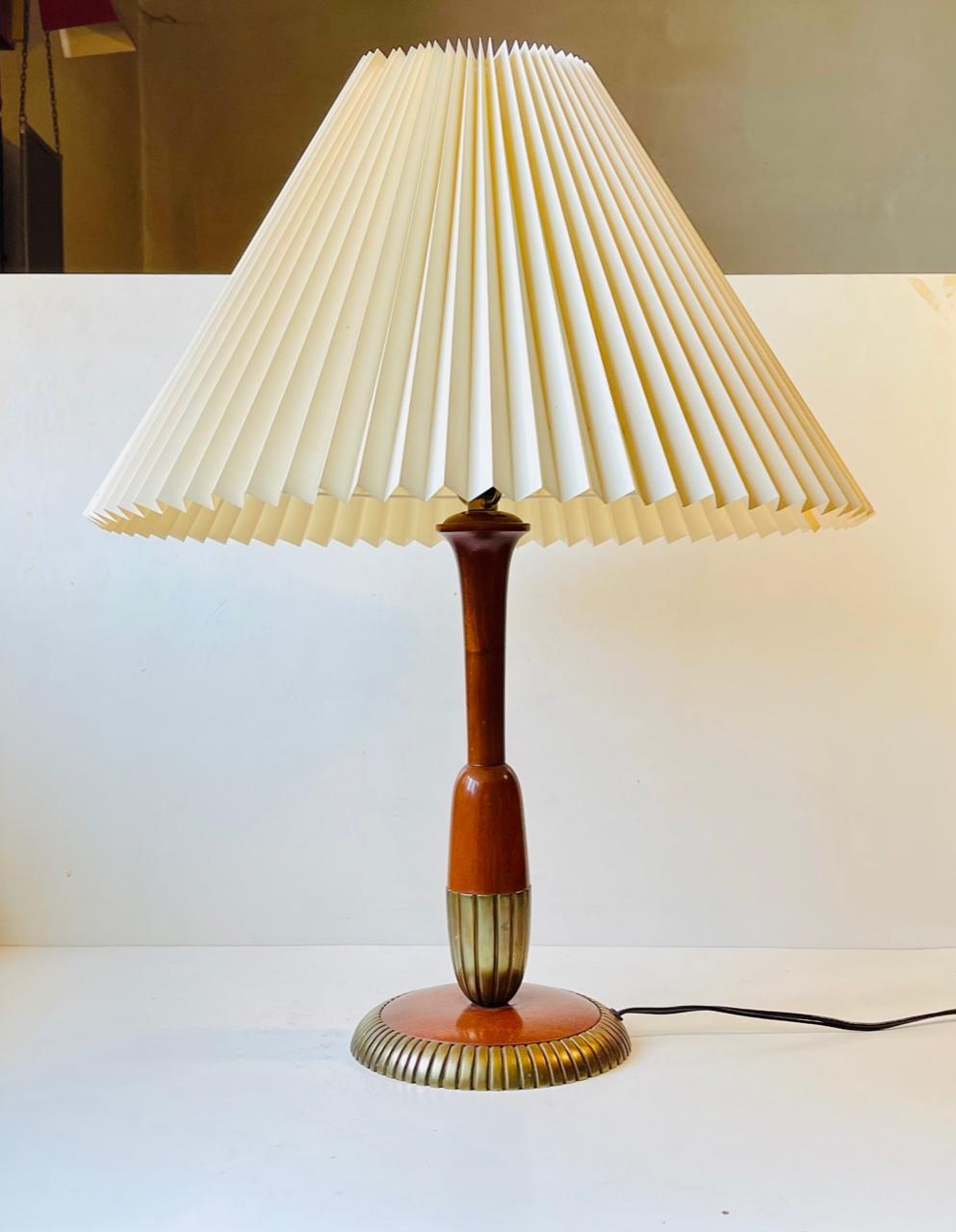 Scandinavian made Art Deco styled table light in walnut fluted brass. Probably made by either Falkenbergs Amaturar, Nordiska Kompagniet or Bergboms in Sweden circa 1950. This fixture features brass shade holder and on/of switch to the bakelite