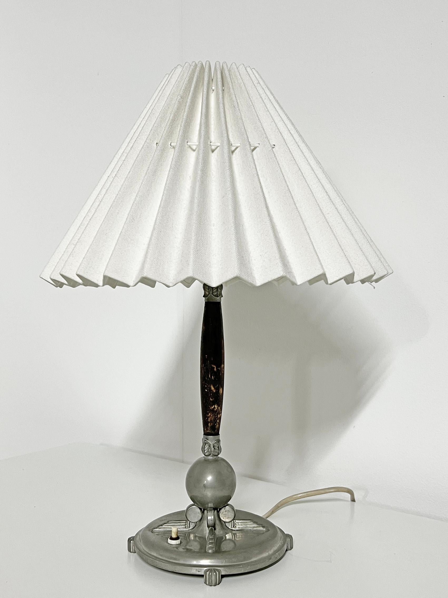 Superbe lampe de table avec de beaux détails art déco, en étain et bois teinté, Lundin & Lindberg -1938.
Signé avec la marque du fabricant. 
Bon état vintage, usure et patine correspondant à l'âge et à l'utilisation.
Patine d'étain, usure sur la