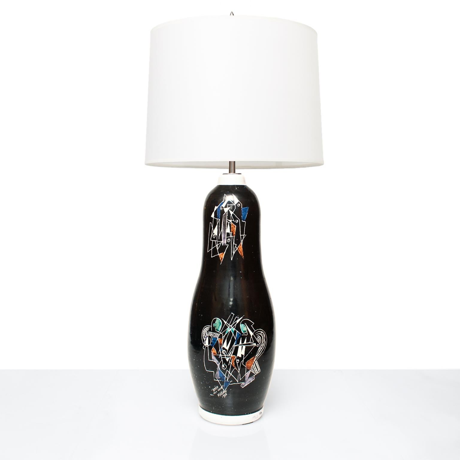 A Scandinavian Modern tall ceramic lamp by Marian Zawadzki for Tilgmans Keramik. The lamp's body is a black glaze which is hand decorated with 2 scenes depicting birds feeding their young in a nest. Signed 