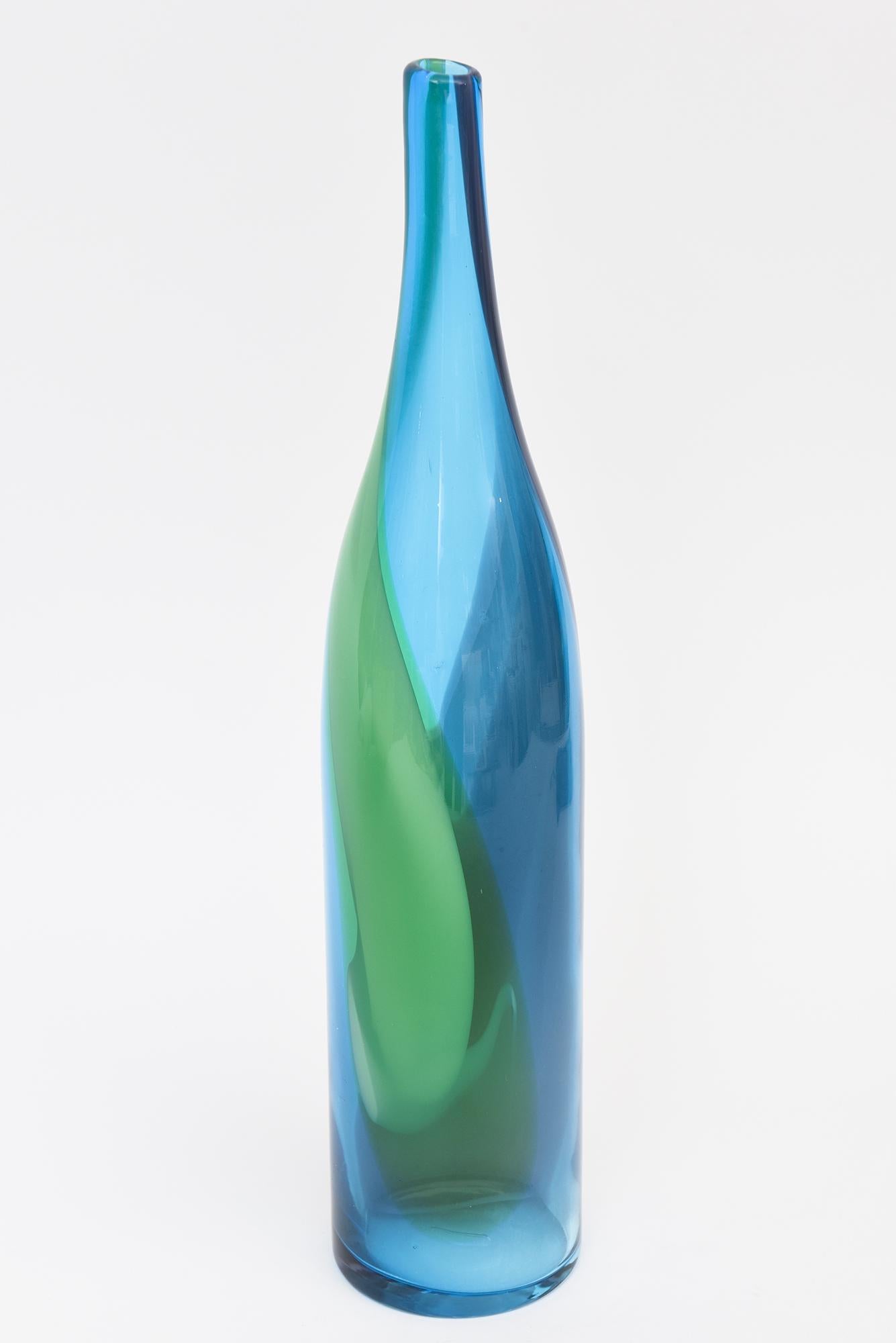 Diese schöne gewirbelte Scandinavian Modern Vintage mundgeblasenem Glas hohe Flasche ist ein Medley von gewirbelten Designs in wunderschönen Farben von blau, türkisblau, grün und lila. Es ist Vintage aus den 1960er Jahren.
Groß und farbenfroh bringt