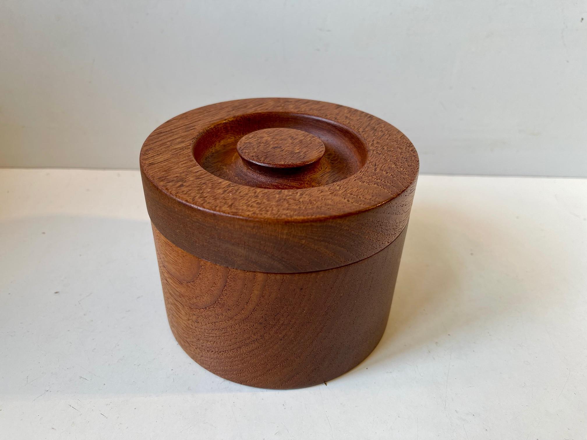 A wellmade jar for tobacco, tea, jewelry etc. Its made from solid engine turned teak and was manufactured for the Copenhagen retailer Illums Bolighus in Denmark during the 1960s in a style reminiscent of Kay Bojesen and Henning Koppel. It is signed