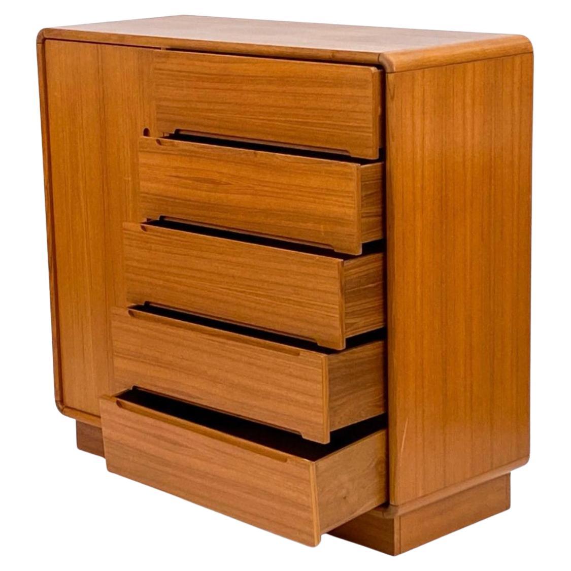 Escandinavo Moderno de teca 5 cajones de ancho armario alto Dresser. Tiene cinco cajones a la derecha y una puerta armario a la izquierda con 2 cajones forrados de fieltro y estantes regulables. Se asienta sobre un zócalo. Alrededor de 1970. Los