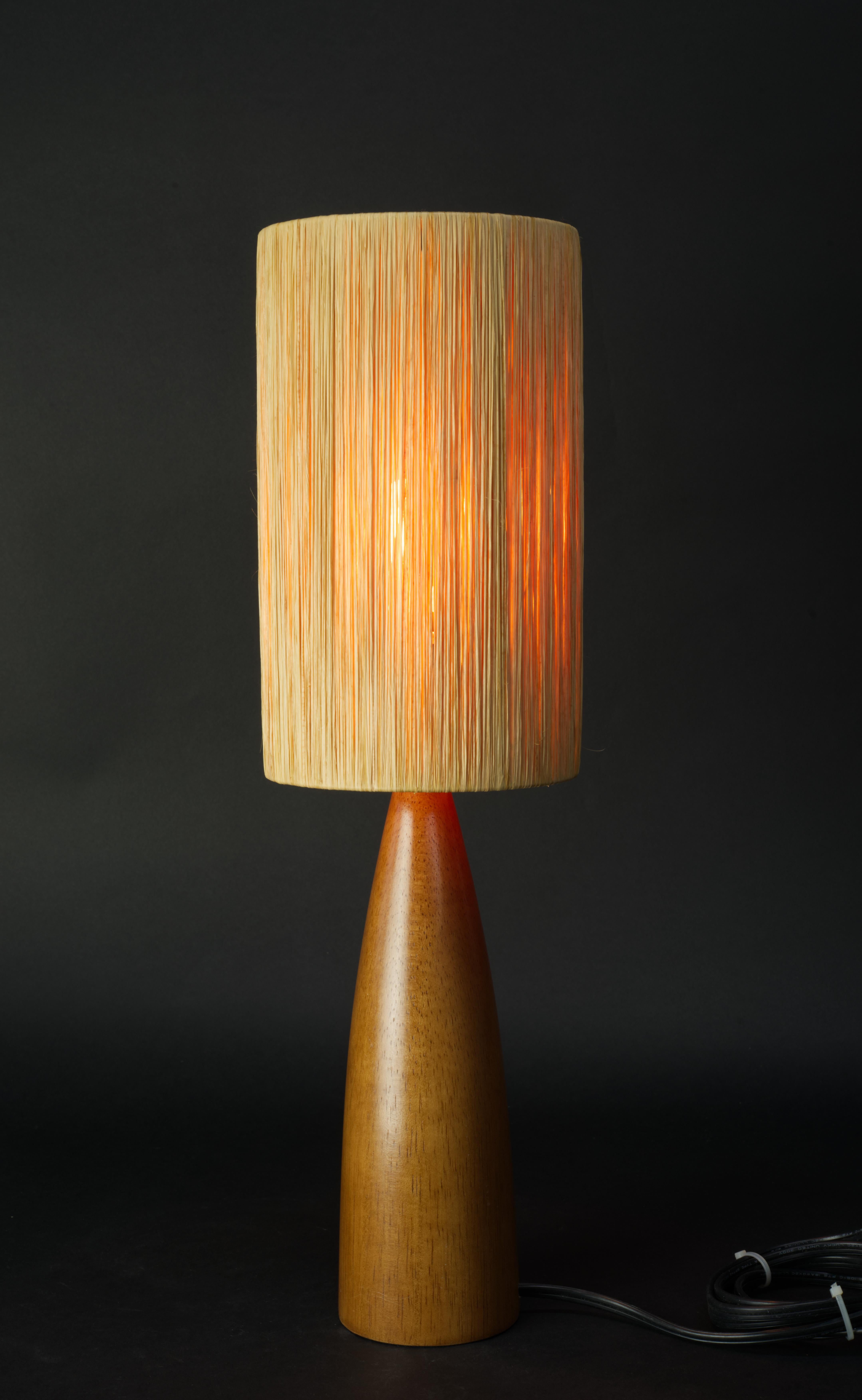  Elongated mid-century Scandinavian modern accent or table lamp is made of teak with straw shade. The lamp is highly decorative and has a small footprint, making it suitable for all living areas.

The lamp is 19.5