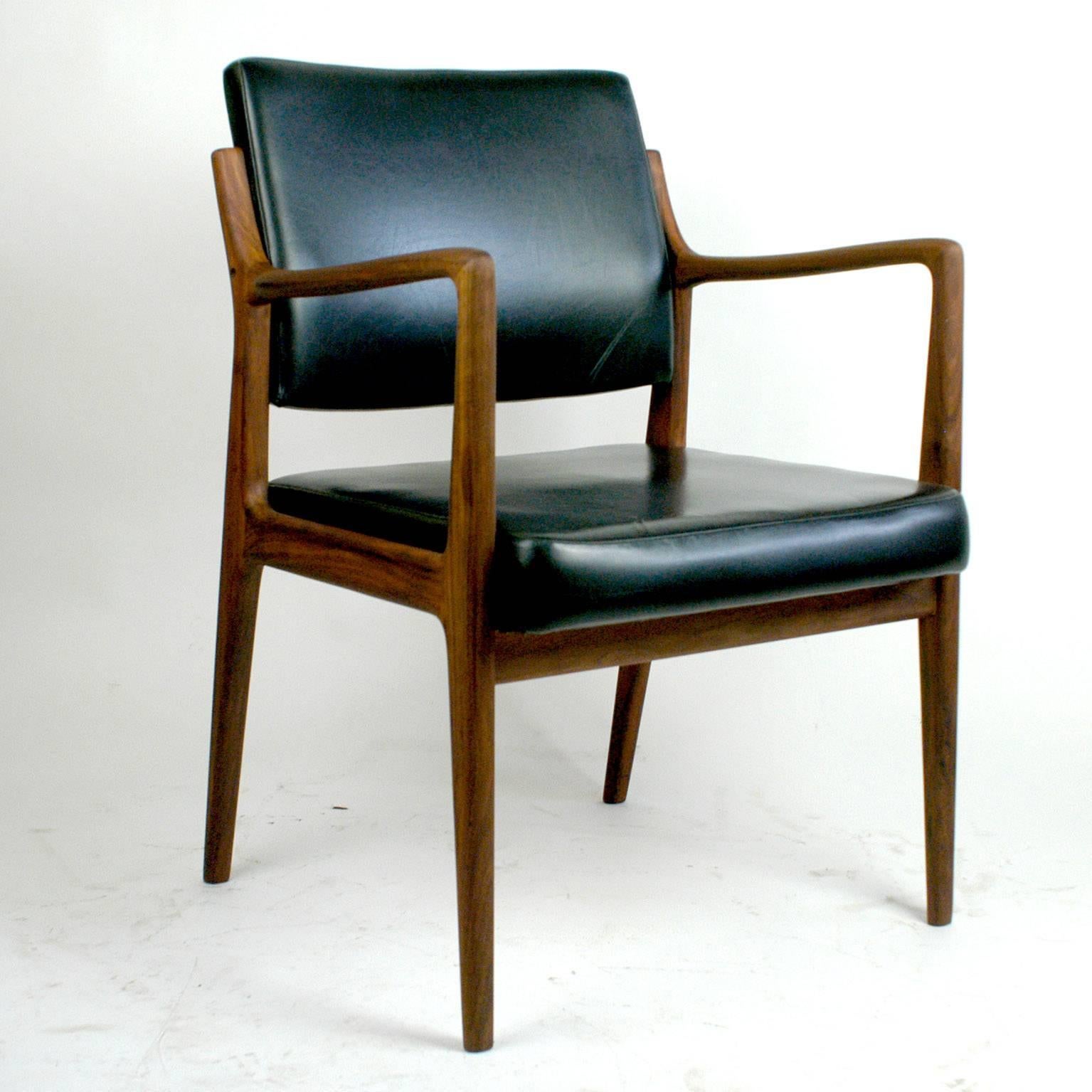This perfect Scandinavian modern armchair features a teak wood frame and a seat - and back cushion with black Leatherette. It was designed in the 1960s by Karl Erik Ekselius for JOC Mobler, Vetlanda, Sweden. The manufacturers brandmark is on the