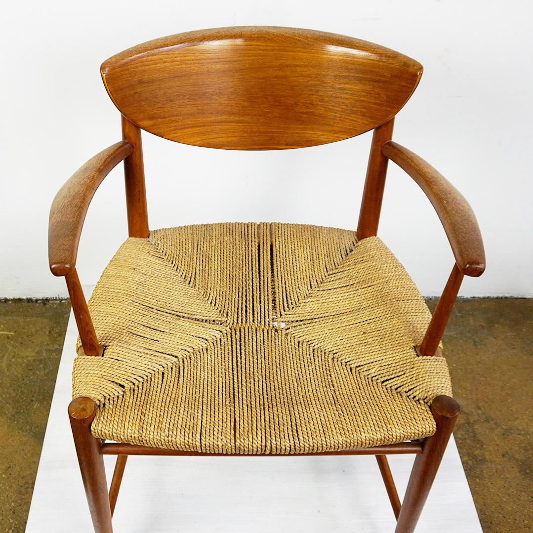 Cet excellent et rare fauteuil en teck massif Mod. 317 a été conçu par Peter Hvidt et Orla Molgard Nielsen au Danemark dans les années 1950. Il se caractérise par une assise en rotin tressé d'origine en très bon état et par des accoudoirs et un