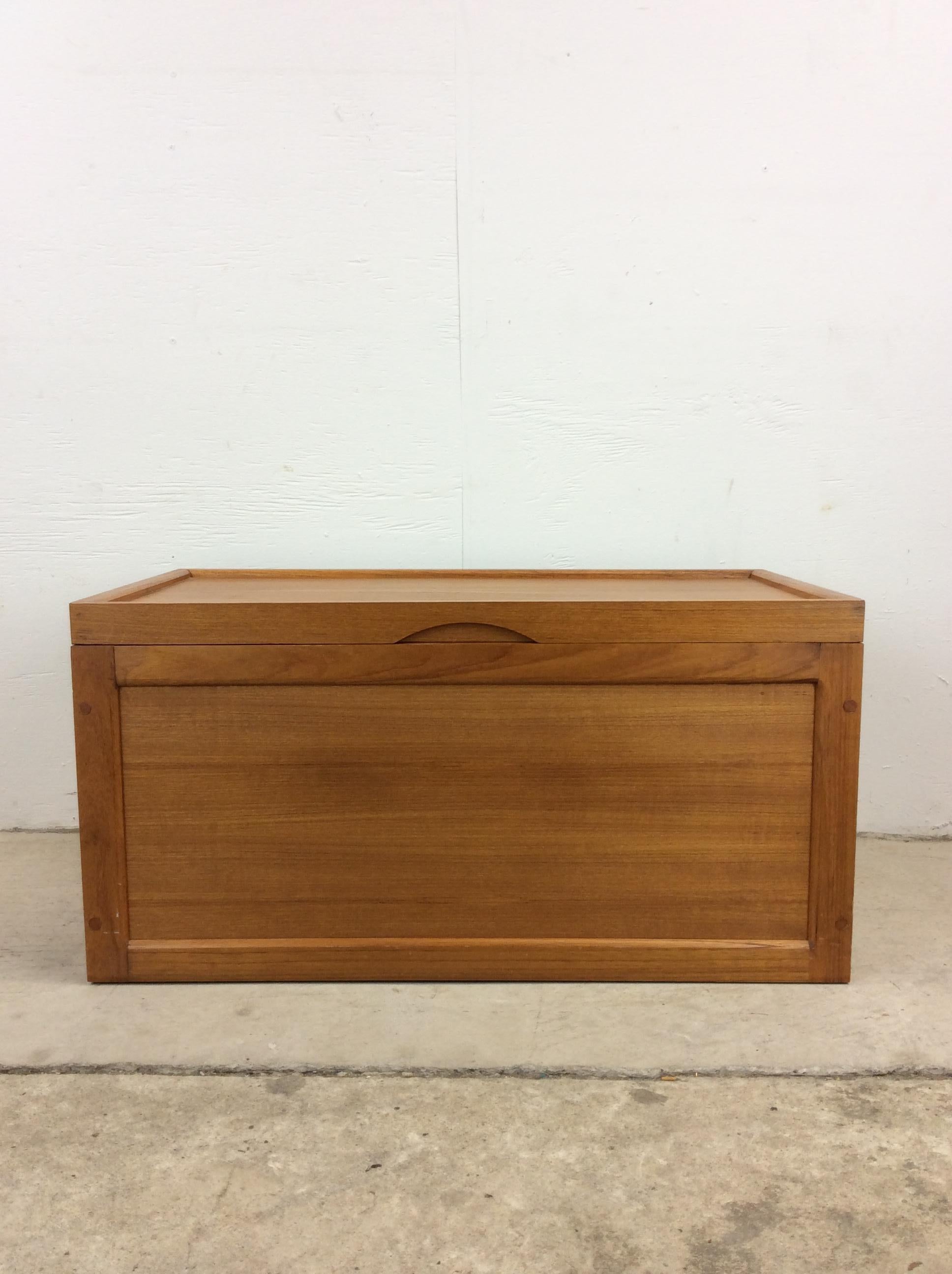 This Scandinavian Modern style blanket chest features solid teak construction, brass accented hinges, and a carved pull.  There is stainless hardware included (presumably to ease the way the lid closes) that is new in packaging but was not installed