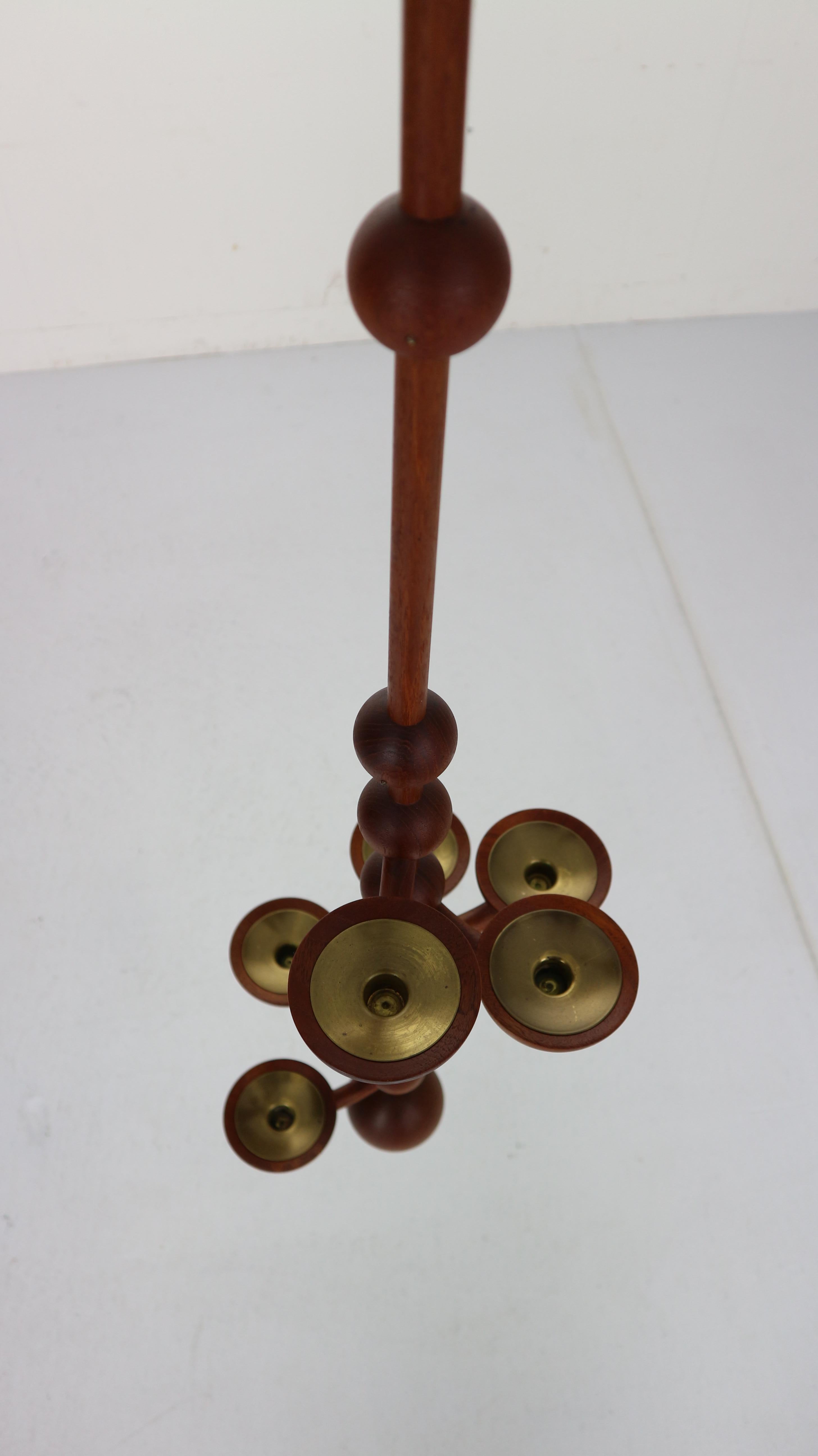 An unique and beautiful candelabra from Denmark made in 1960s period. The candelabra is meant to be hung like a mobile of candle light.
Made from solid teak wood and six brass candle holders for regular size candles.
      