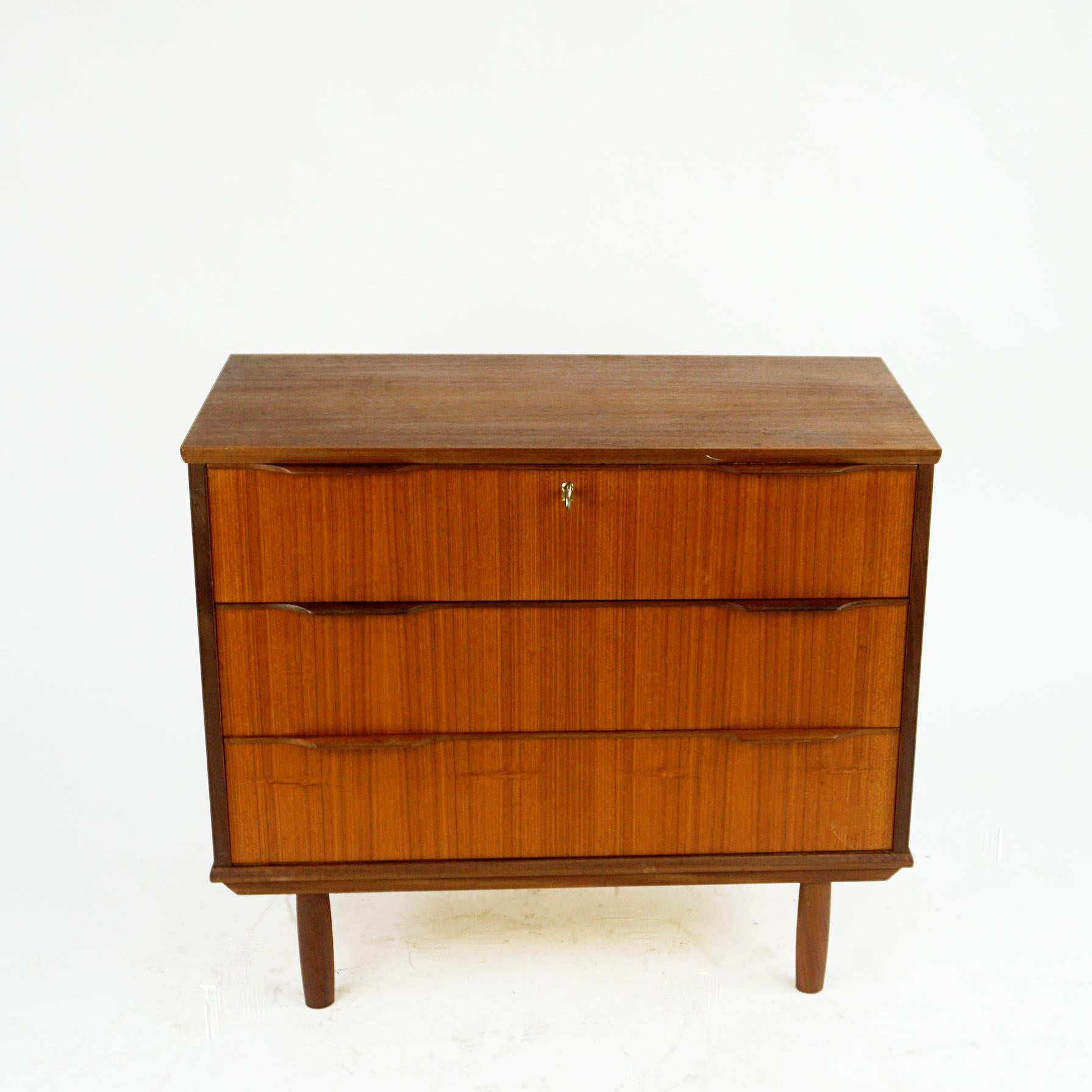 Scandinavian modern teak chest of three drawers manufactured in the 1960s in Denmark. Authentic example for Danish modern design from this period. 
A functional design where all the prominence falls on the expressive natural grain of the wood and