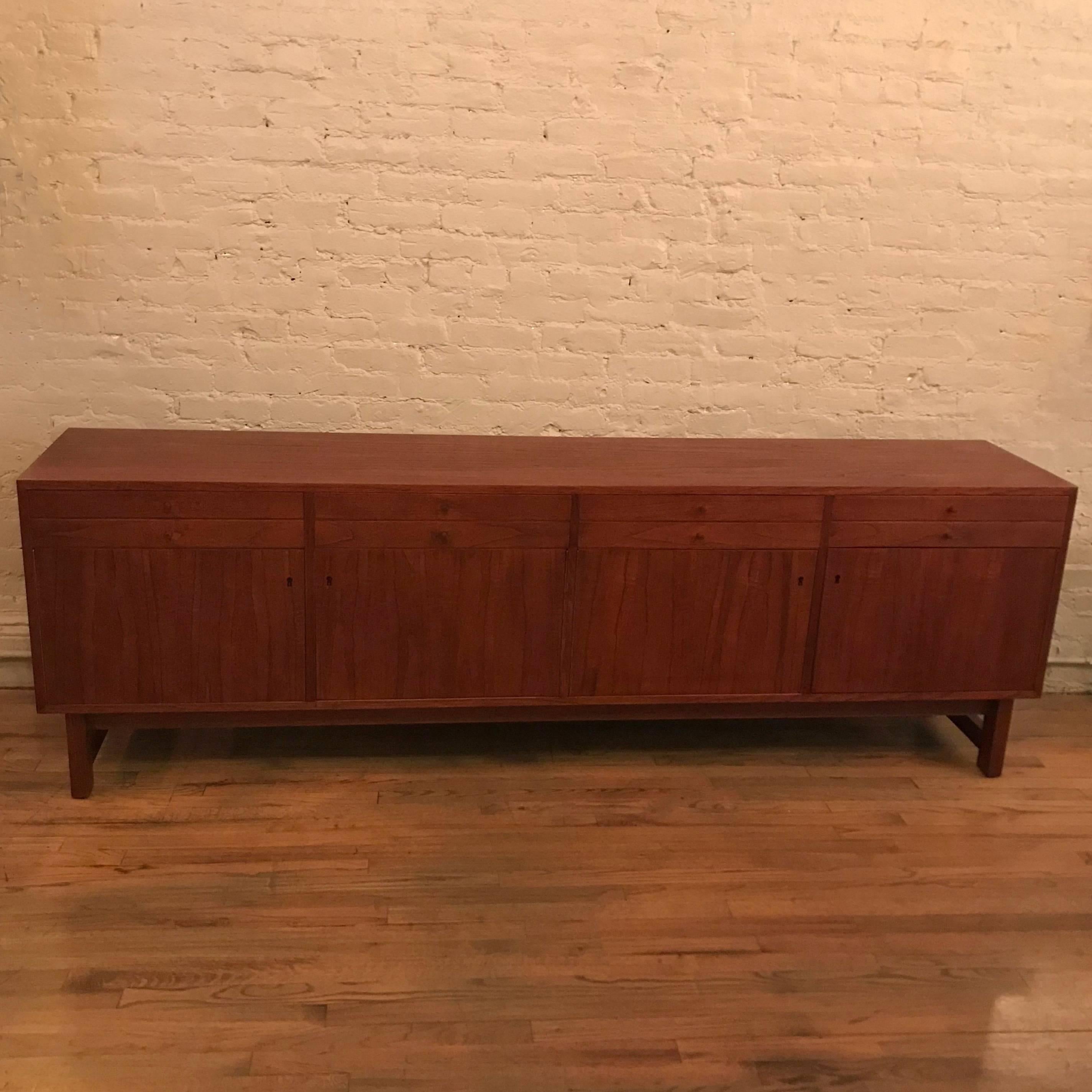 Scandinavian modern, teak credenza or sideboard made in Sweden features top drawers with tubular pulls and lockable cabinets below.