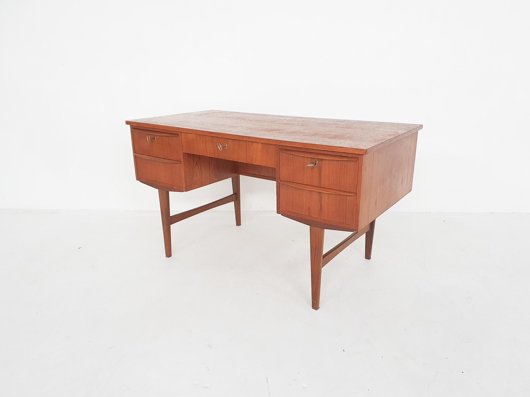 Nice small teak desk with 6 smaller drawers and one large drawer in the middle. The back has space for books or decorative objects.
The three top drawers can be locked. The two top drawers on the sides do not slide very smoothly.
We have