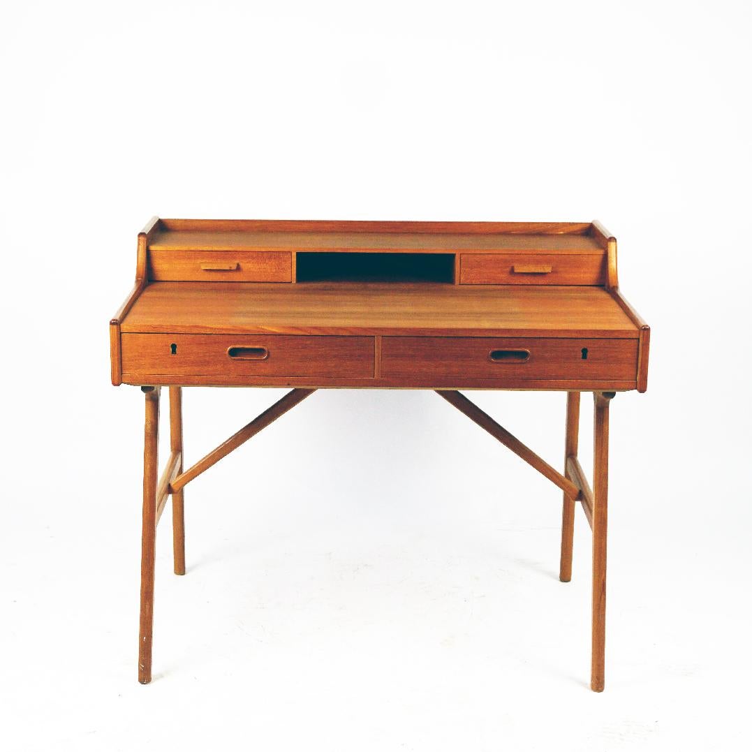 This Handsome Scandinavian Modern teak desk was designed by Arne Wahl Iversen for Vinde Møbelfabrik Denmark in the 1950s. This compact yet functional desk is beautifully constructed, with added features for office organization. Spacious writing