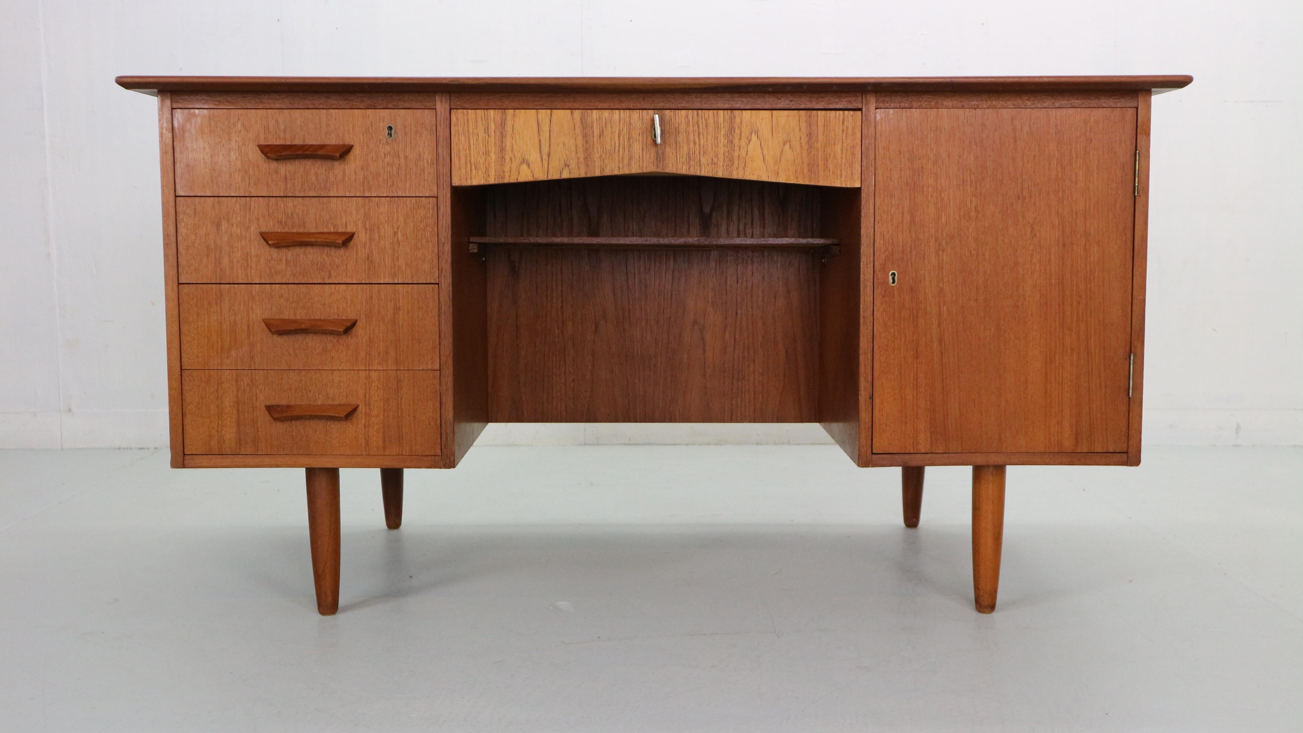 Scandinavian modern period desk made in 1960's Denmark. 
The desk made of teak wood and is in a good vintage condition with beautiful wooden patina. Desk consists of 5 front side drawers- two of them has a lock and one fitting key and cabinet with