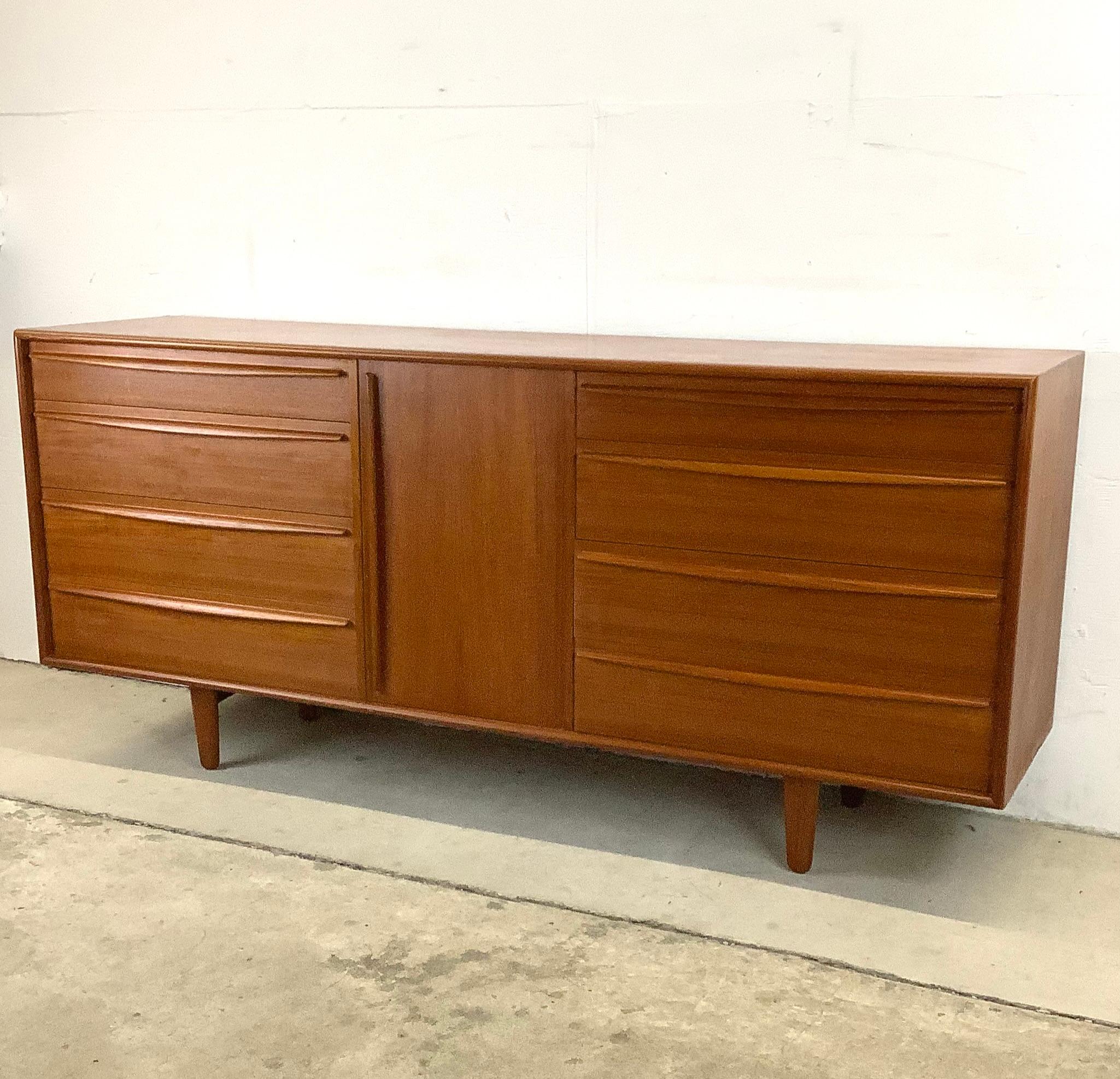 This stunning vintage modern teak dresser from Lyby Mobler features a stunning array of eight dovetailed drawers combined with center shelved cabinet. The stylish storage in this vintage modern piece offers plenty of bedroom organization options in