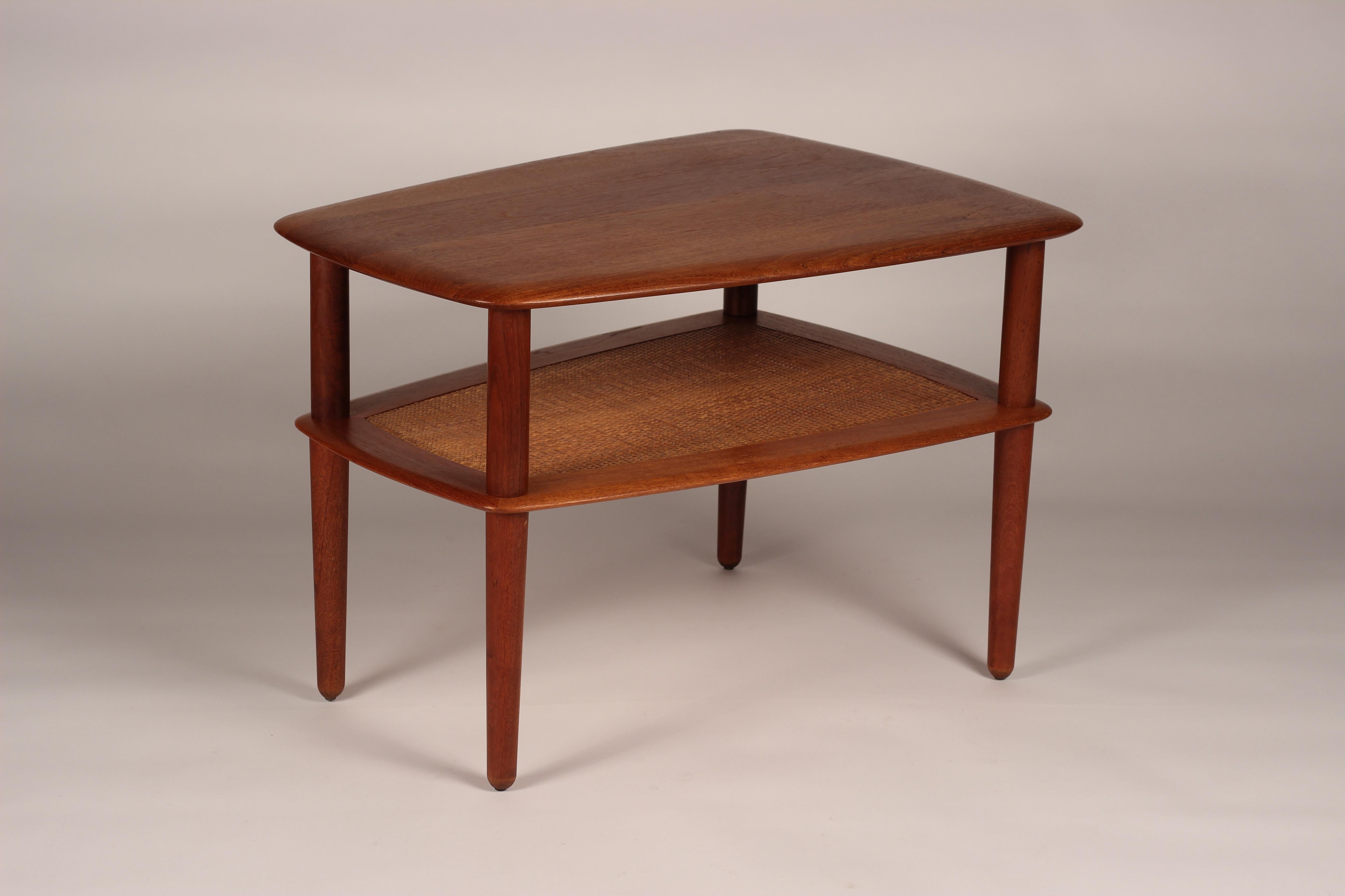 A restored and in good condition, solid teak and caned two-tiered end or side table. Bearing makers mark verso.

We invite you to follow us and look at our Storefront for further 20th Century Design pieces.

General note: Shipping quotes, as
