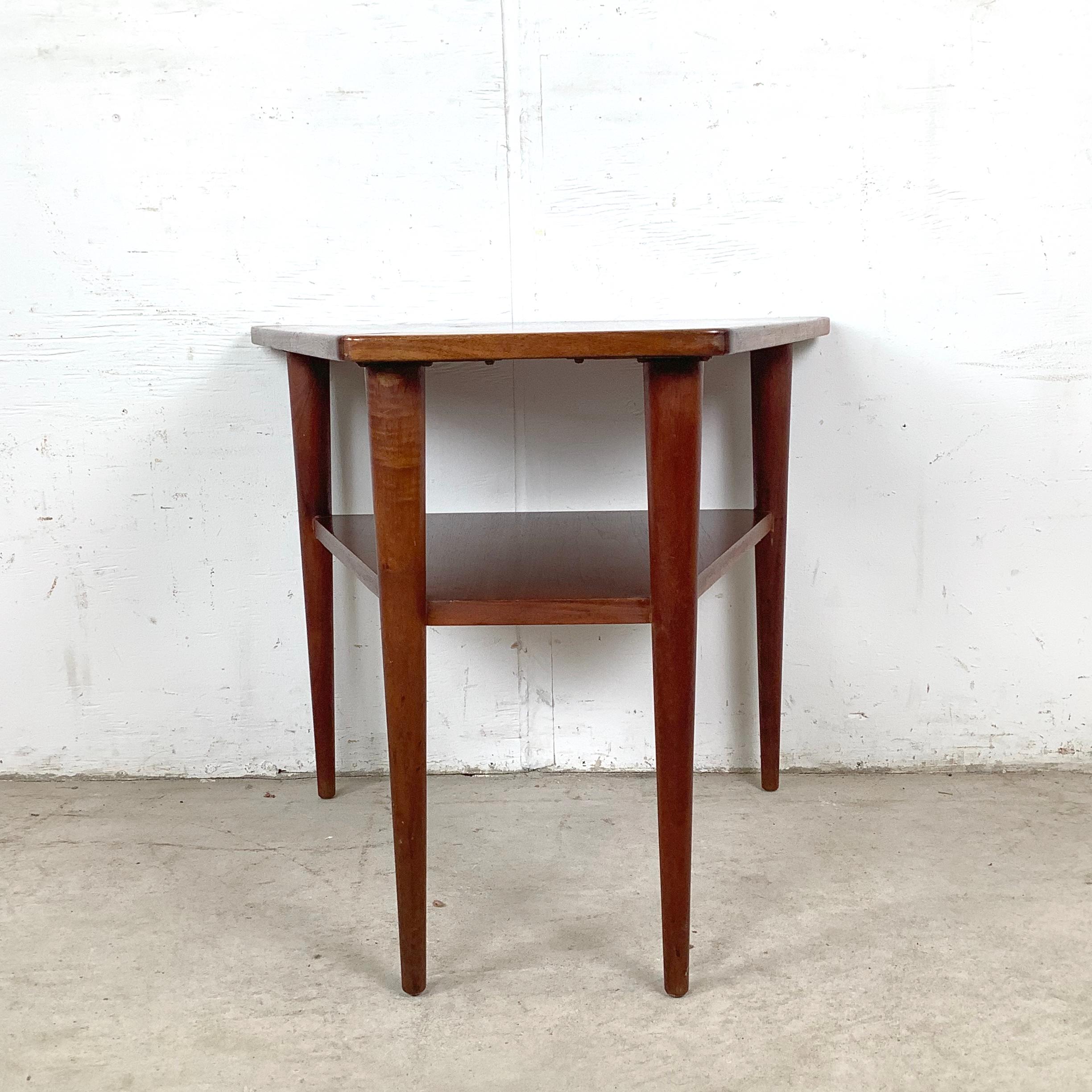 Aporta calidez de mediados de siglo a tu espacio con esta mesa auxiliar vintage de teca con un distintivo tablero trapezoidal y un útil estante inferior. Sus elegantes proporciones y líneas limpias encajan tanto en ambientes clásicos modernos como