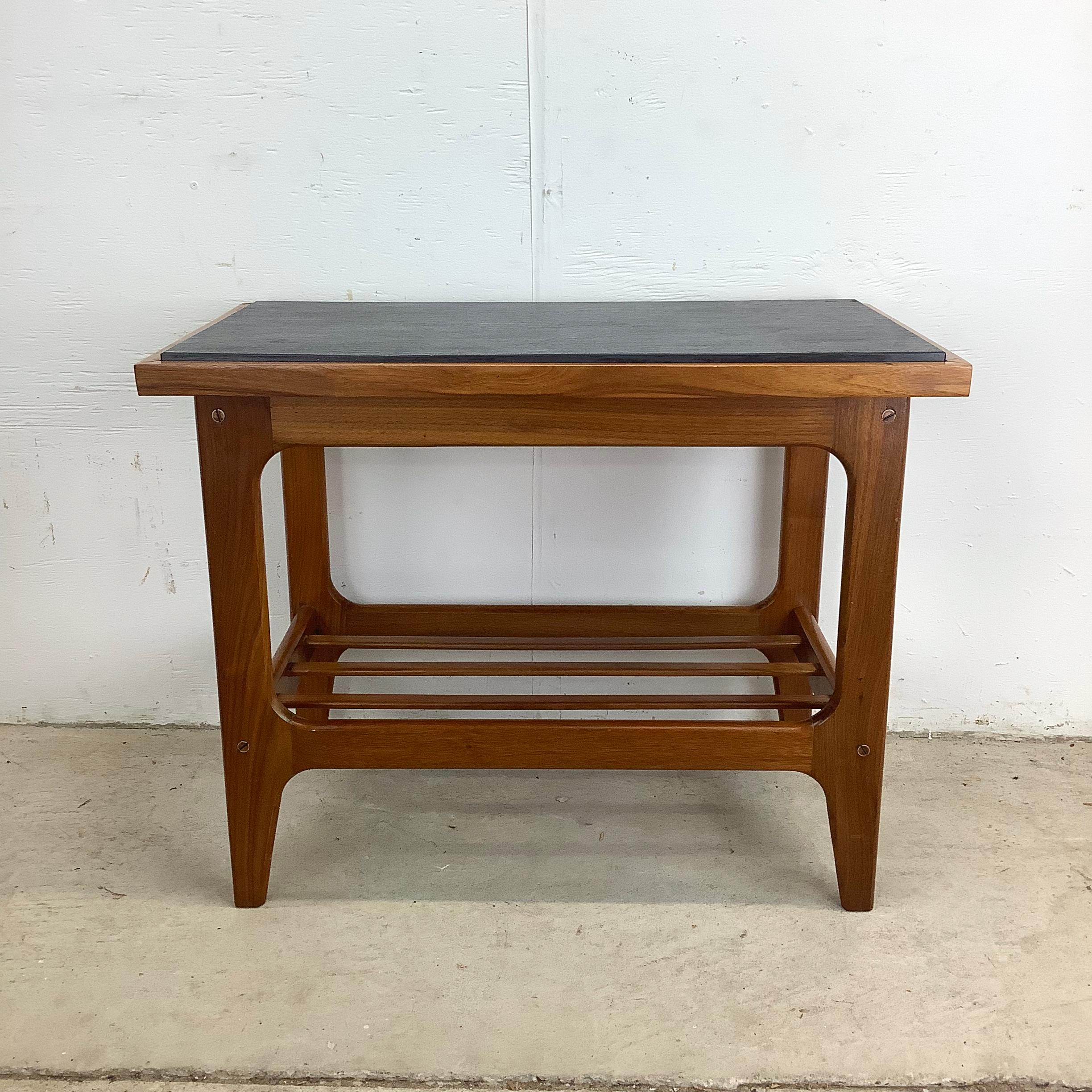 A superb example of Danish Modern design, this end table embodies the restrained sophistication and material harmony that defined mid-century Scandinavian furniture. The warm teak frame is paired with a finely honed black slate top, creating a