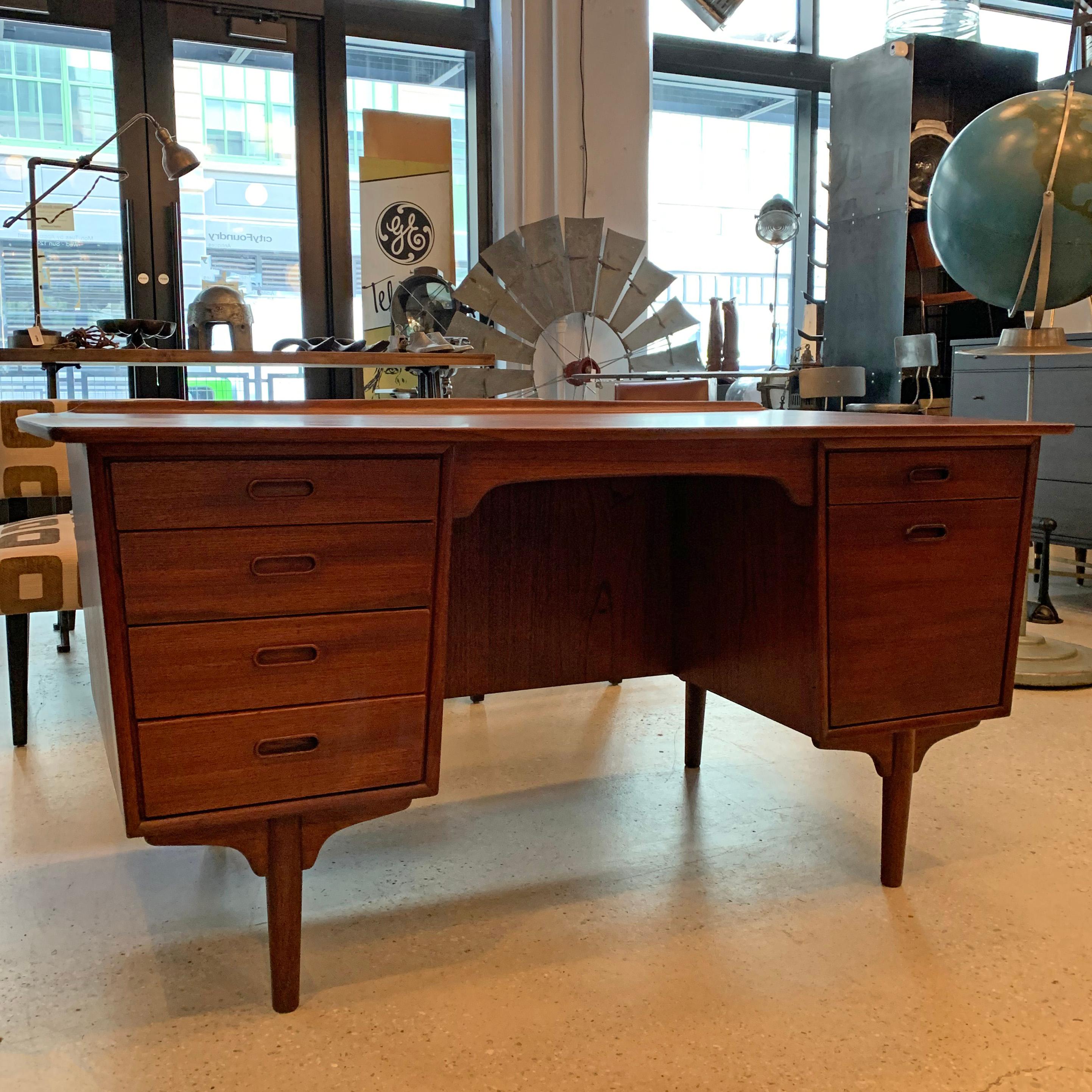Danish modern, double pedestal, teak, executive desk by Svend A. Madsen for Sigurd Hansen features wonderful detailing throughout; 6 drawers with recessed handles, a finished bookshelf front and contrasting grain top with back lip and peaked sides.
