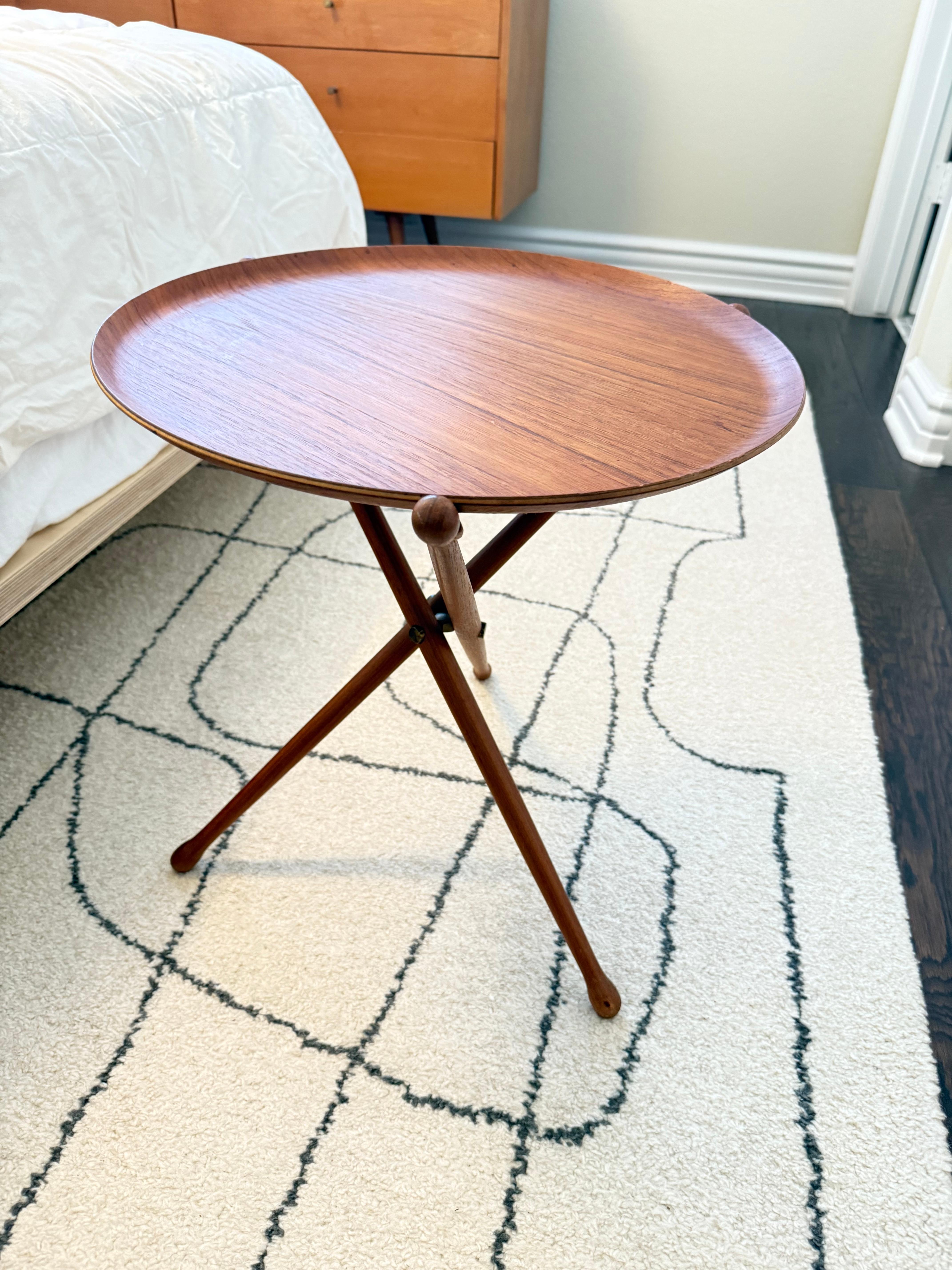 Scandinavian Designer Mid Century Modern Teak Folding Tray Table
A refined example of mid-century Scandinavian design by Nils Trautner for Ary Nybro, Sweden. This piece features a beautifully crafted 17.5-inch round teak tray, supported by an