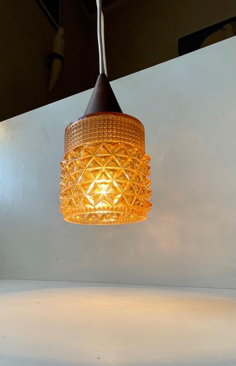 Small Scandinavian hanging light composed of pressed honey glass in diamond pattern glass and a top in solid teak. Unknown Scandinavian maker/design in a style reminiscent of Lisa Johansson-Pape. It is fitted with a E27 light bulb, 3 meters new