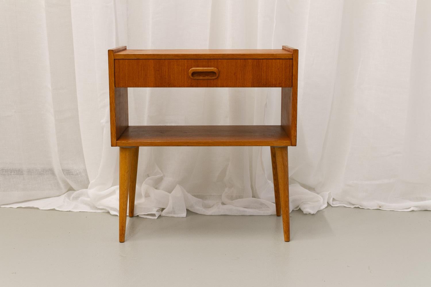 Scandinavian Modern Teak Night Stand, 1960s.
Lovely small bedside table in teak veneer with single drawer and open shelf. Round tapered legs in solid oak.
Elegant and versatile.
Good vintage condition with patina consistent with age and use