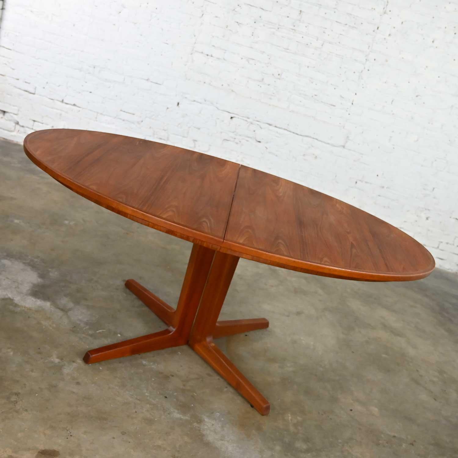 Exquisite vintage Scandinavian Modern teak oval dining table #410 with 2 leaves, oval table pad, and pedestal base attributed to Bernhard Pedersen & Son. Beautiful condition, keeping in mind that this is vintage and not new so will have signs of use