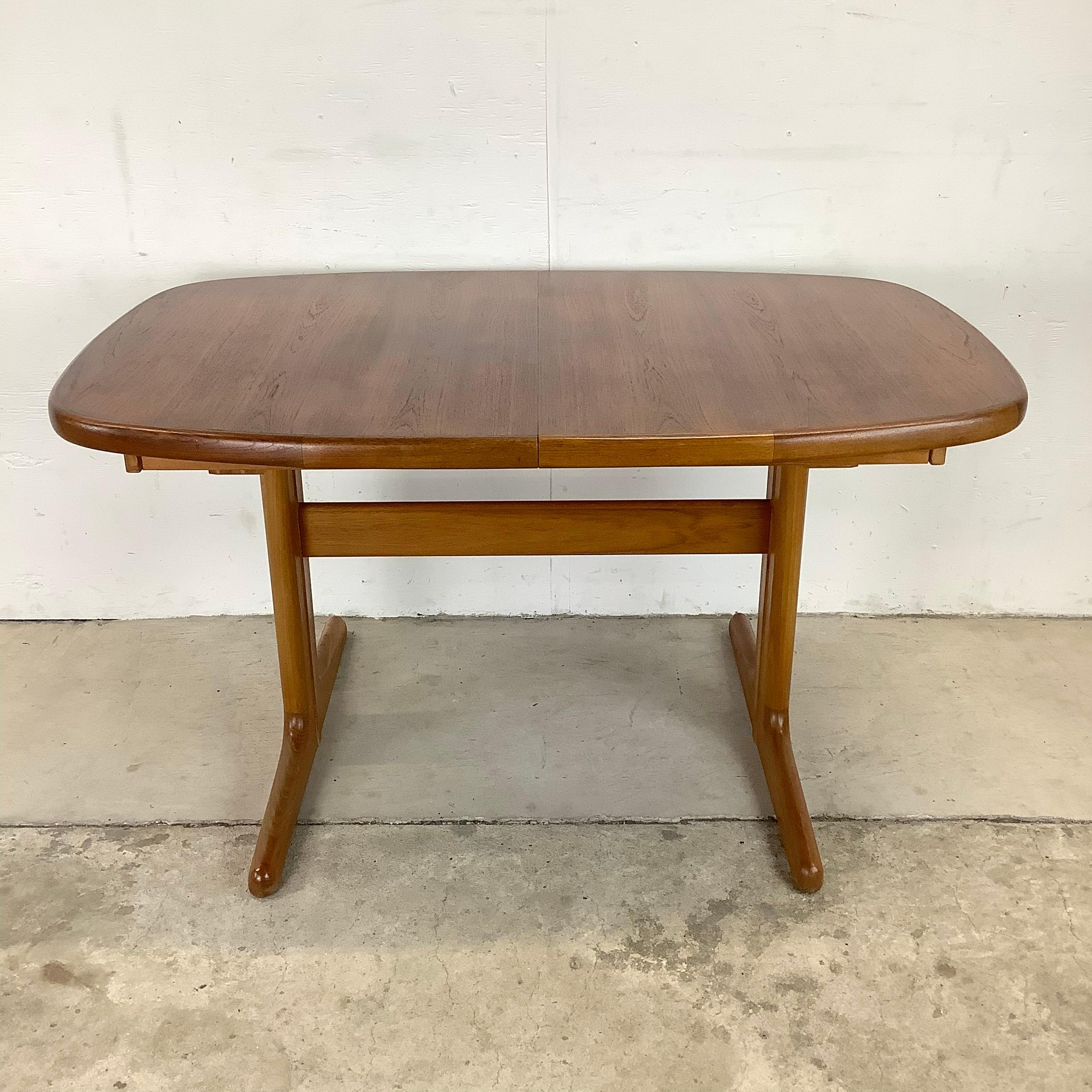 This impressive Scandinavian Modern dining table features a striking vintage teak finish and unique pedestal design. The two removable table leaves allow the expansive dining top to expand from 53 inches wide to 92 inches wide, making this a