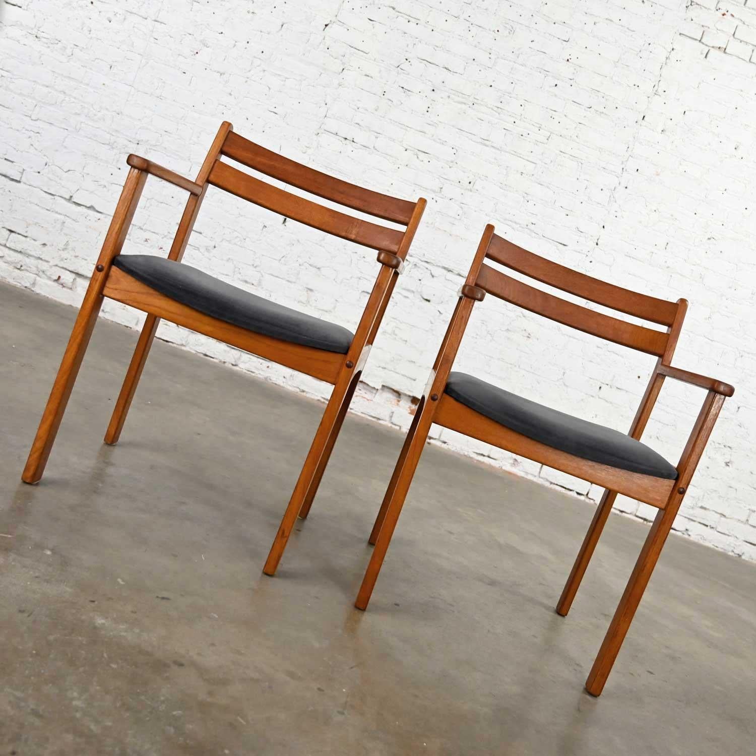Stunning Scandinavian Modern teak pair of armchairs with their original brushed charcoal fabric seat cushions. These are marked made in Denmark, but we have been unable to identify maker. Beautiful condition, keeping in mind that these are vintage