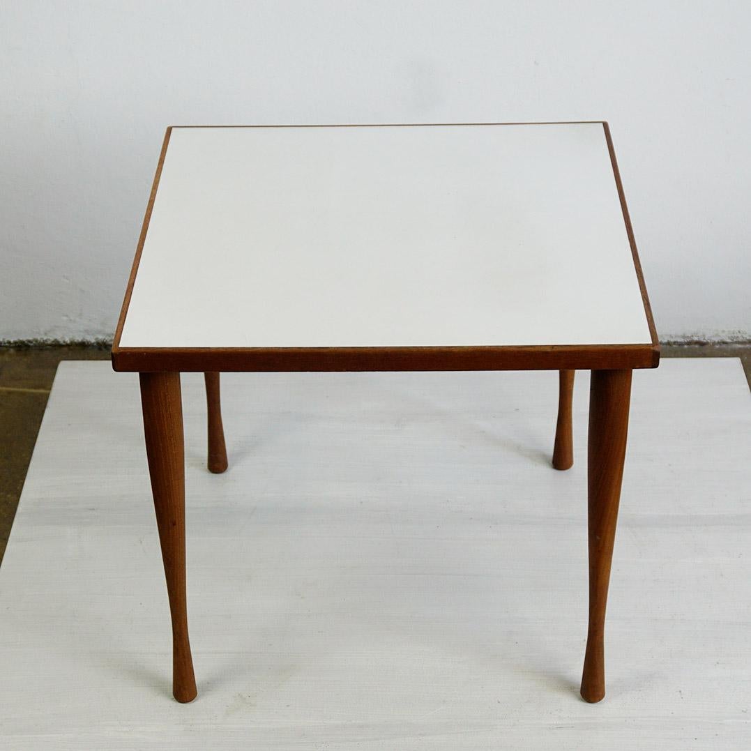 This Scandinavian Modern side or coffee table mod. No 5560 was designed by Hans C. Andersen Denmark in the 1950s.
It features a beautiful handcrafted teakwood frame and a white Formica top. On the underside you can find an original label. 
This