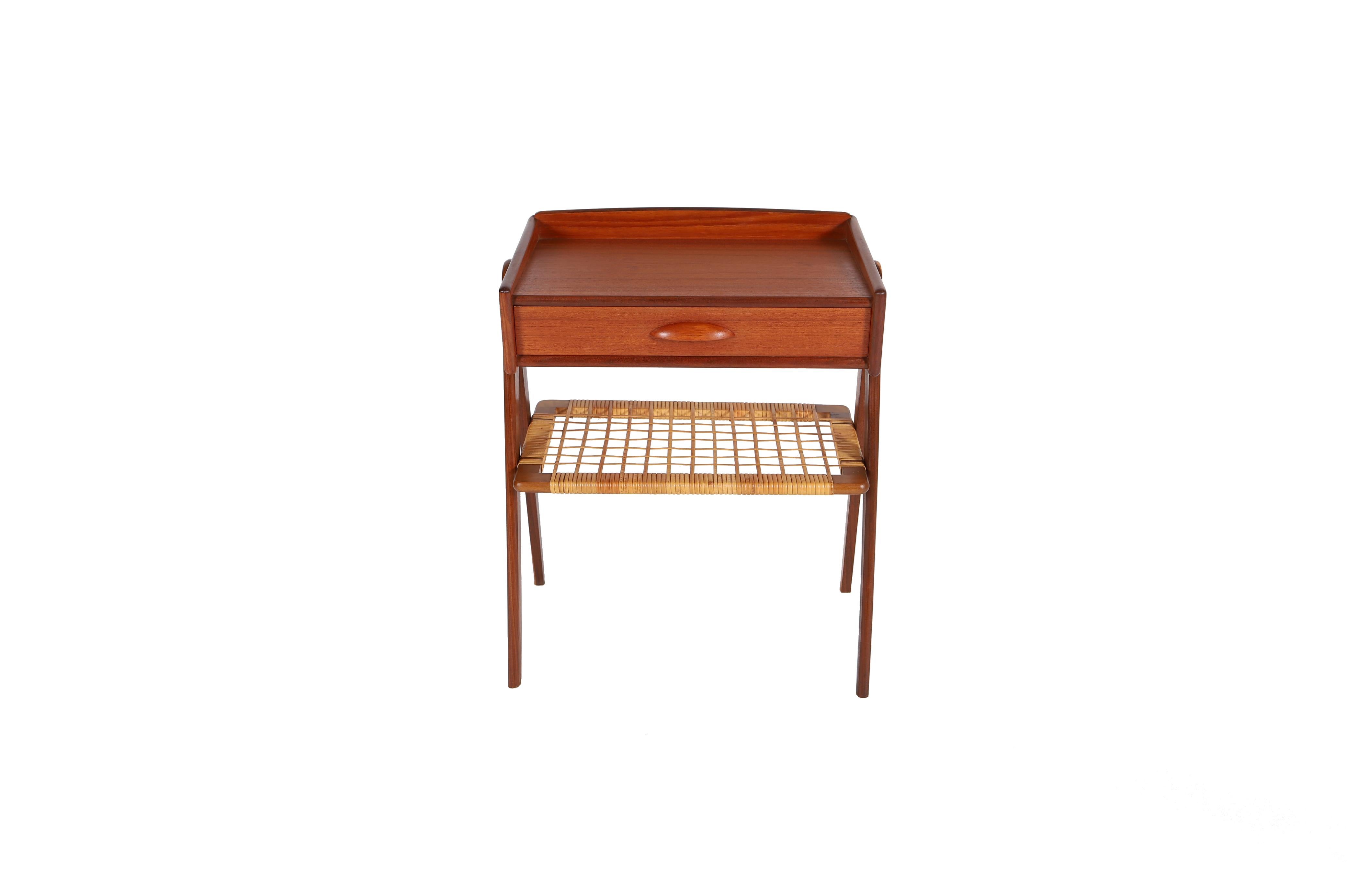 Dieser zierliche Beistelltisch mit umgekehrten V-förmigen Beinen, einer Ablagefläche aus Rohr und einer kleinen Schublade mit Griffleisten.  Soren Rasmussen Design.

Die professionelle und fachgerechte Restaurierung von Möbeln ist ein fester