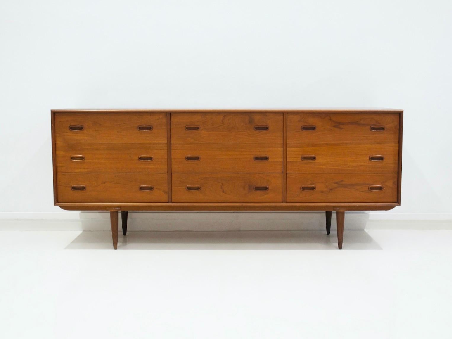 Credenza in teak in stile scandinavo con nove cassetti degli anni '60. Gambe affusolate e cassetti con tiretti incorporati.