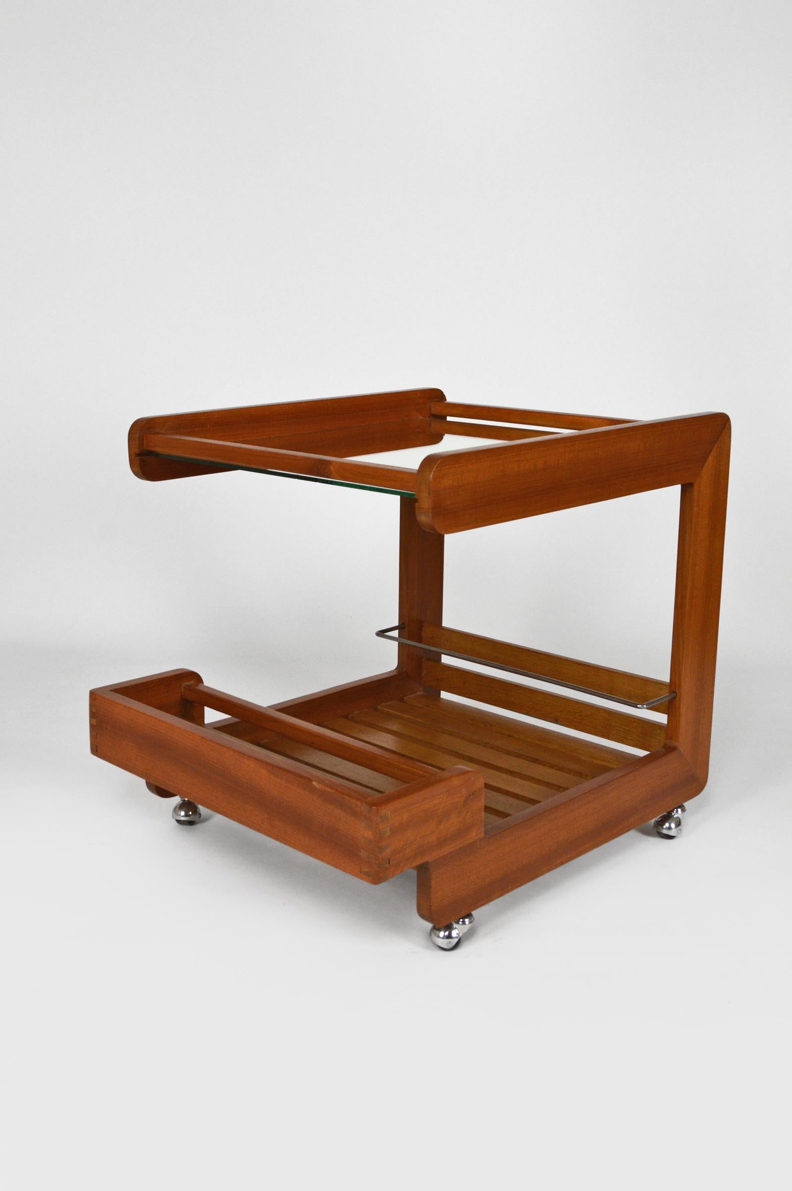 Rare cubic service table / trolley / bar cart.

Structure in solid teak. 
A mirror acts as a top shelf. 
Presence of a steel bar to hold bottles. Functional chrome wheels.

Mid-century Modern, Scandinavia, circa 1970.

In very good