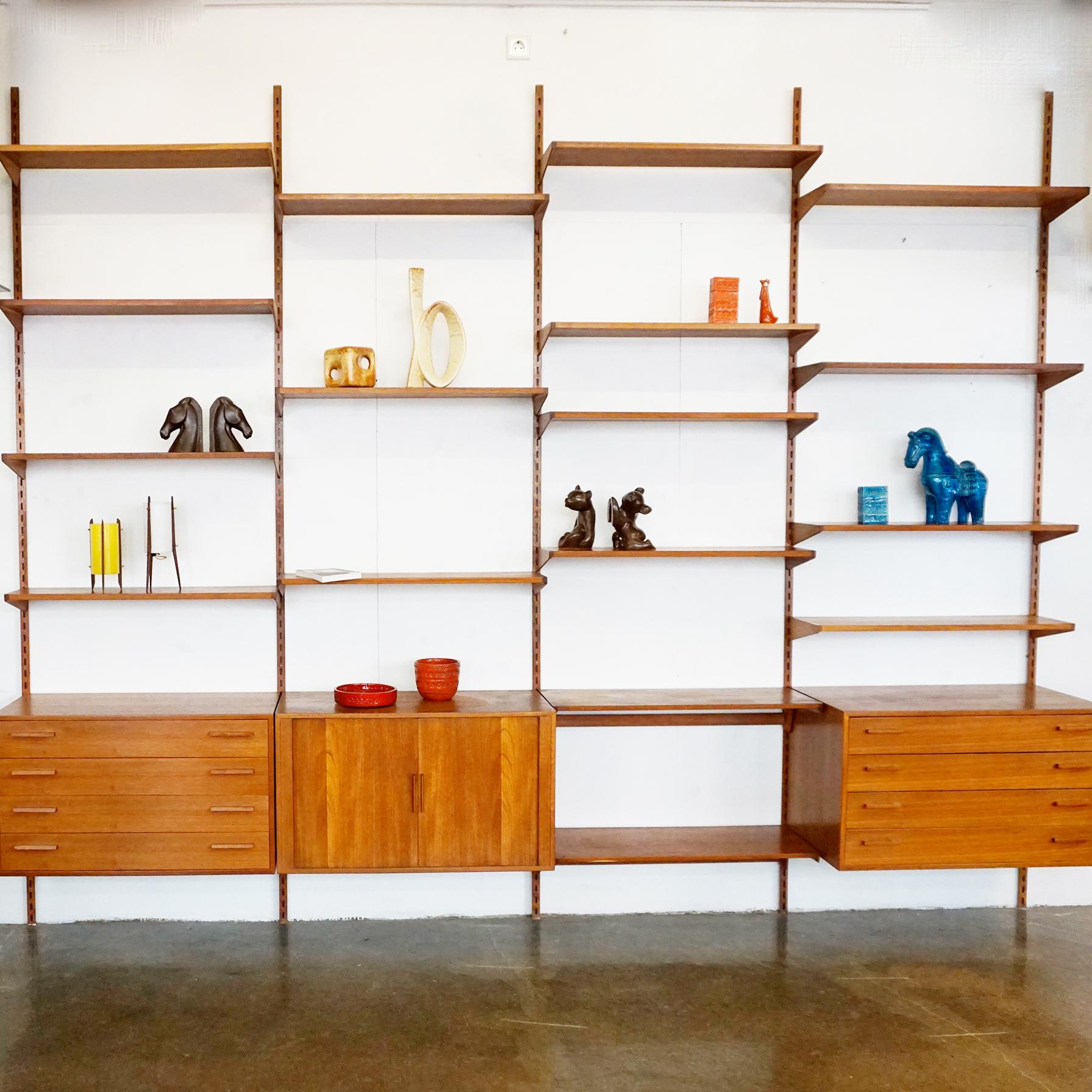 This stunning Danish modern style wall system has been designed by Kai Kristiansen in the 1960s and is made of teakwood. Kai Kristiansen was a real craftsman, this wall system shows it all.
It consists of two cabinets with drawers, one with tambour