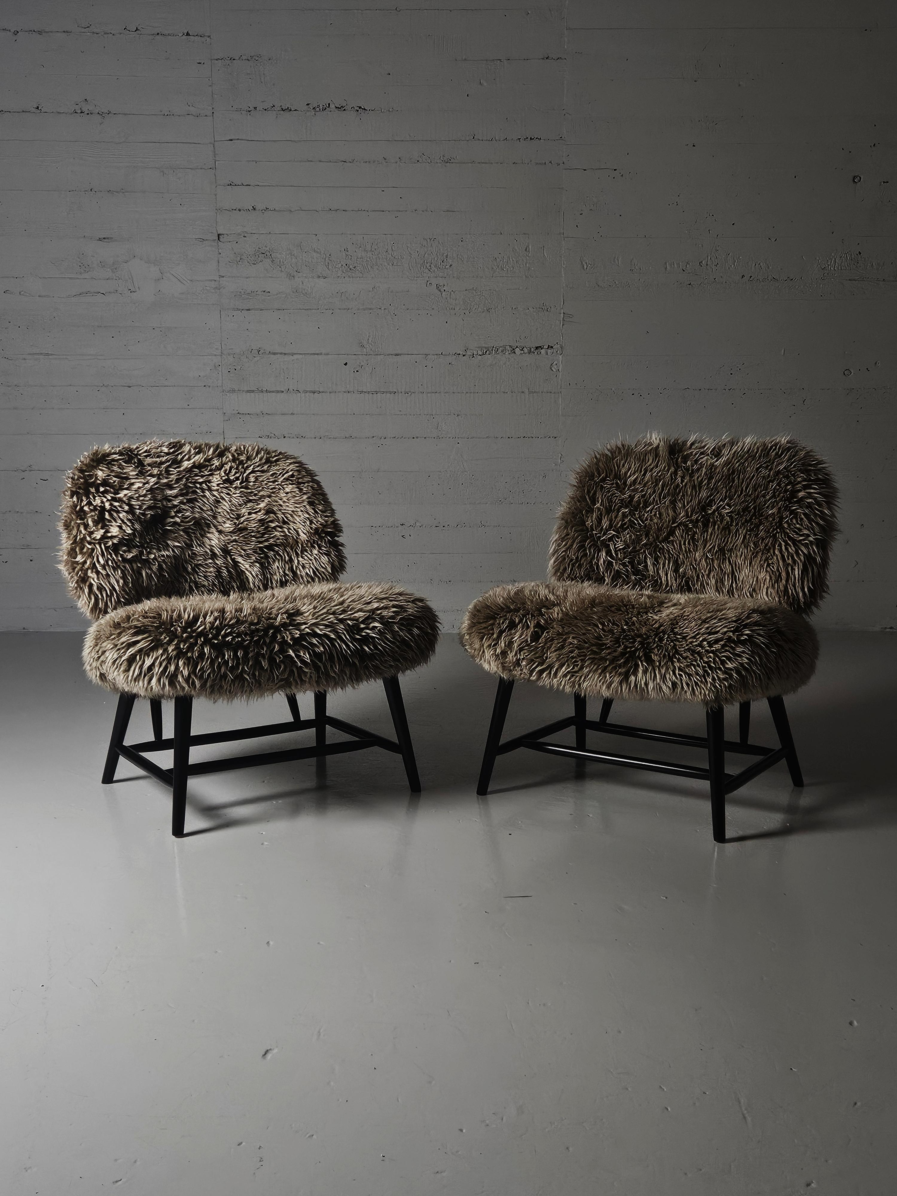 Pair of easy chairs designed by Alf Svensson for Bra Bohag, Ljungs Industrier, Sweden, during the 1950s. 

Model is called 'Teve'.

Body in beach lacquered black and upholstered in lovely long haired sheepskin. 