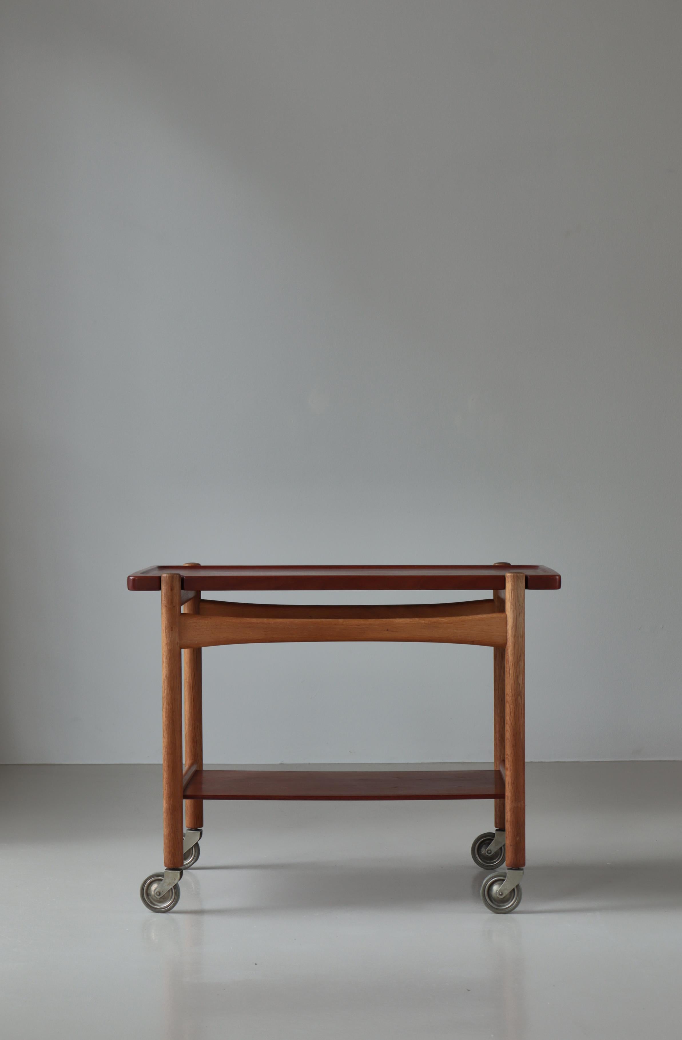 Rare vintage tray table / serving trolley by Hans J. Wegner in solid teak & oakwood. Manufactured by cabinetmaker Andreas Tuck in the 1960s. The table top can be removed and used as a serving tray. The table has aged beautifully with an amazing deep