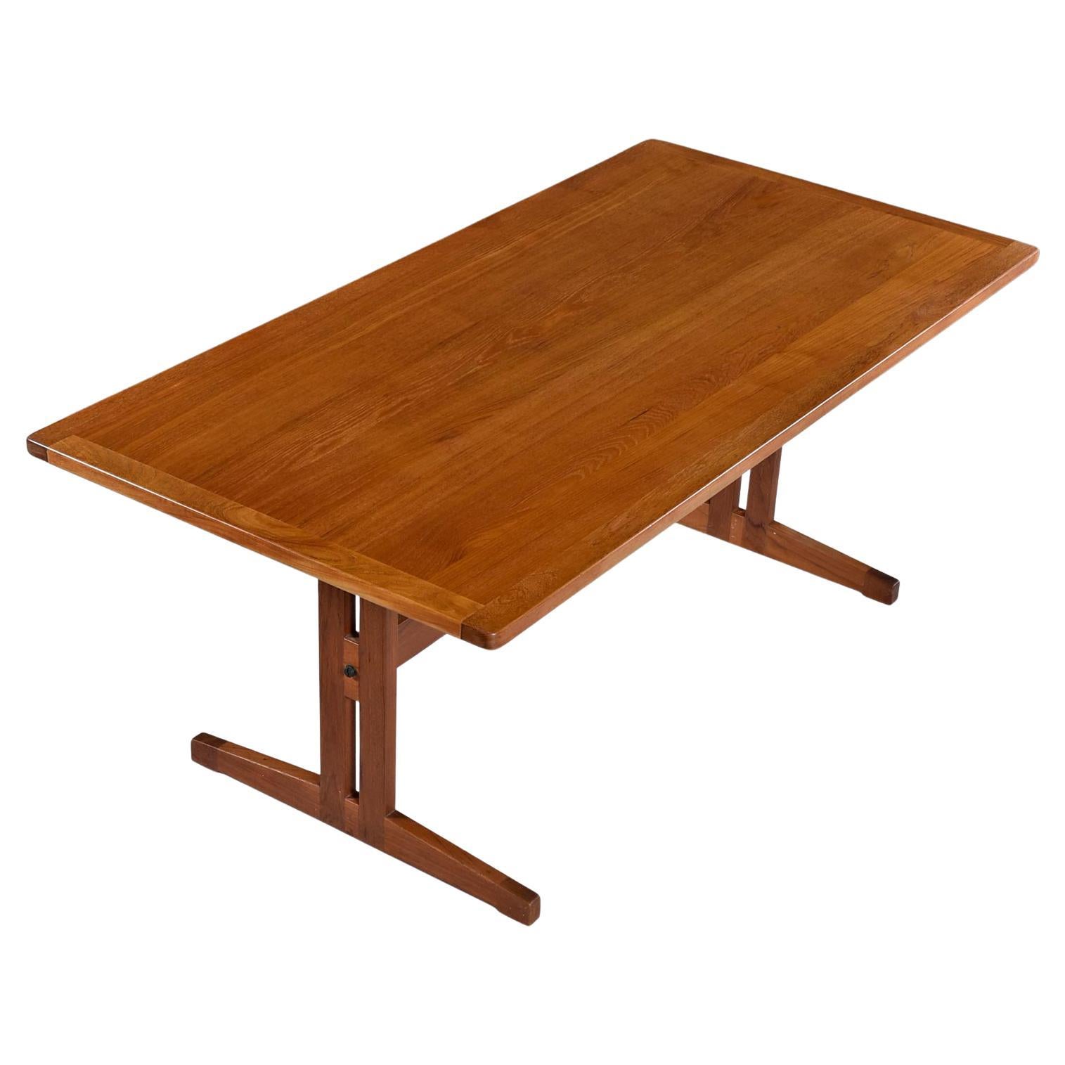 Vintage Danish teak trestle base dining table. This table has a beautiful tiger stripe effect to the decades old teak wood. The top is a mix of teak veneer over hardwood and thick, solid teak edge banding outlining the entire table. The trestle leg