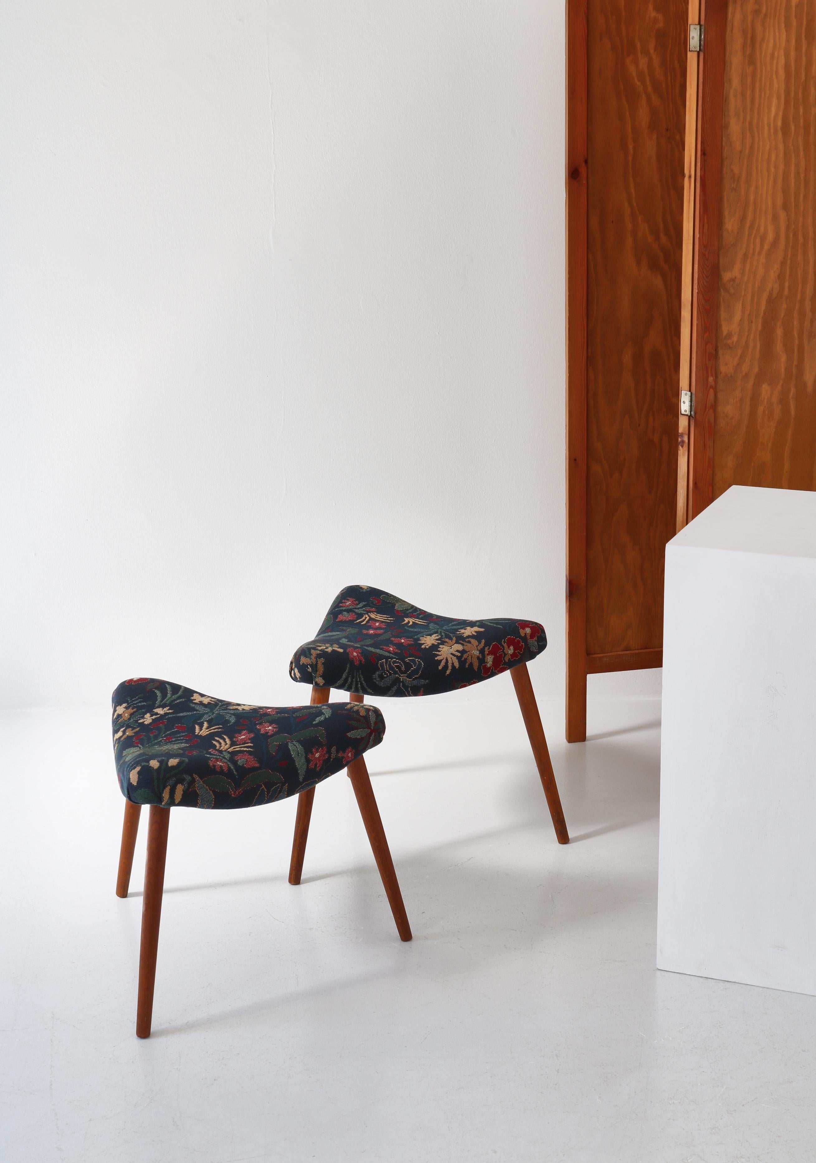 Pair of triangular stools made by a Danish cabinetmaker in the 1950s. The stools are made of an elegant curved wooden frame, that has been reupholstered in unique vintage hand woven tapestry with floral motifs. The legs are made from turned solid