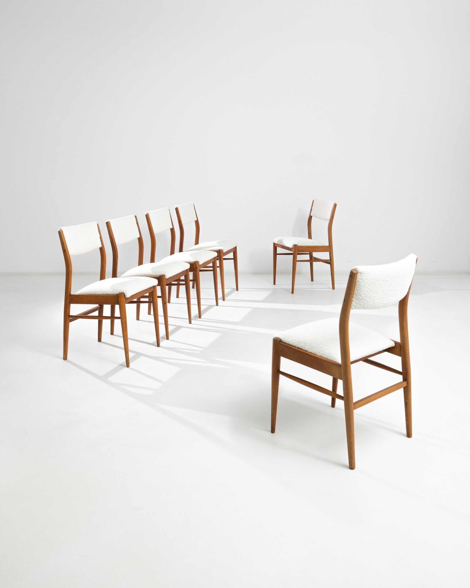 A set of six dining chairs made in Scandinavia, featuring large upholstered backrests, upholstered seats and tapered legs connected by side stretchers. The slightly angled backrest allows for a comfortable posture, enhanced by the fluffy powder