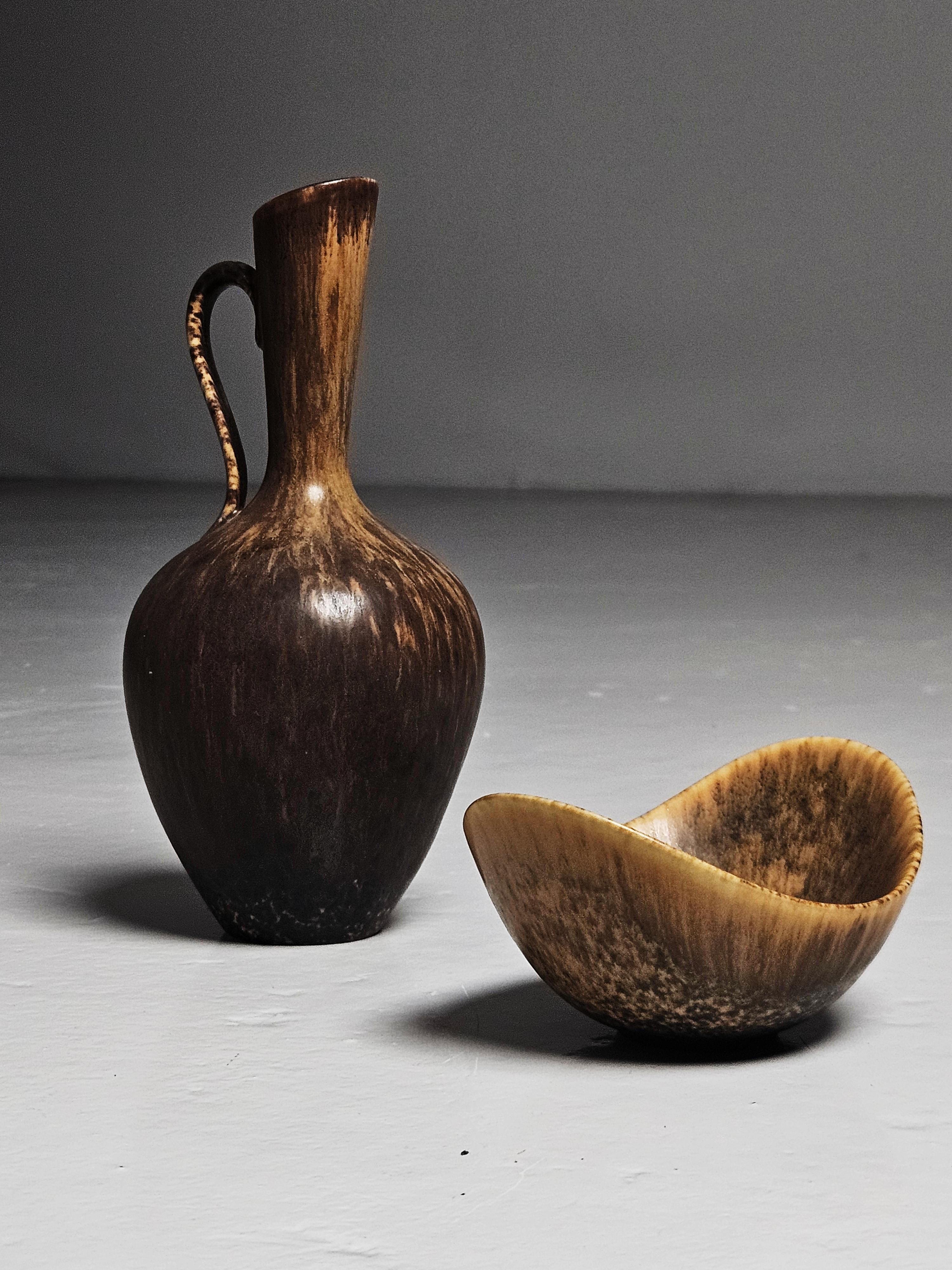 Small bowl and vase designed by Gunnar Nylund and produced by Rörstrand, Sweden, during the 1950s. 

Both with beautiful earthy toned glaze. 

Dimensions of bowl: Height: 1.97 in (5 cm)Width: 2.96 in (7.5 cm)Depth: 3.94 in (10 cm)

Dimensions vase:
